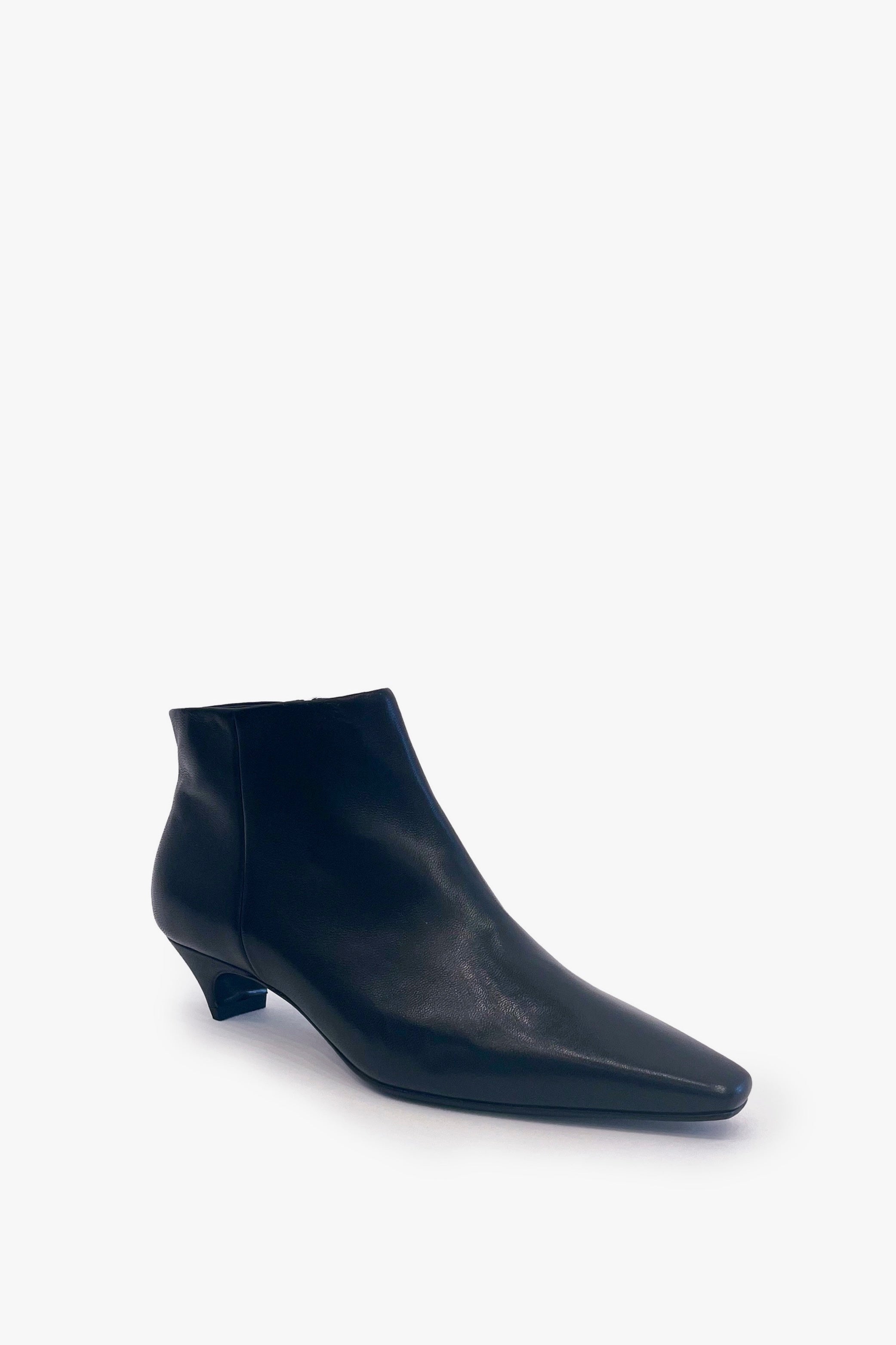 A single black leather ankle boot with a pointed toe and a low kitten heel, photographed from a side profile on a clean white background.
