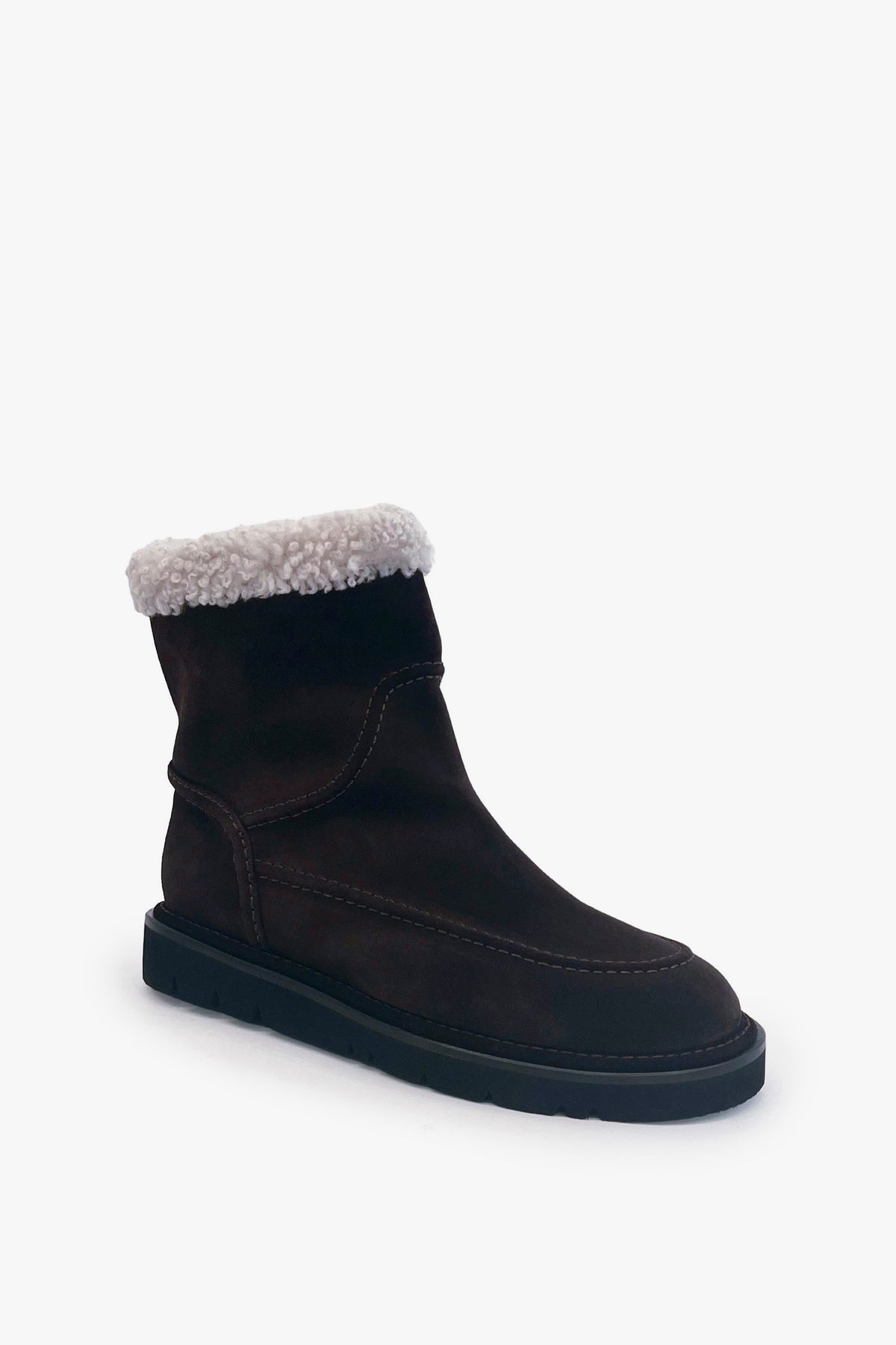 A dark brown suede ankle boot with a light beige sherpa lining visible at the collar, set against a plain white background.