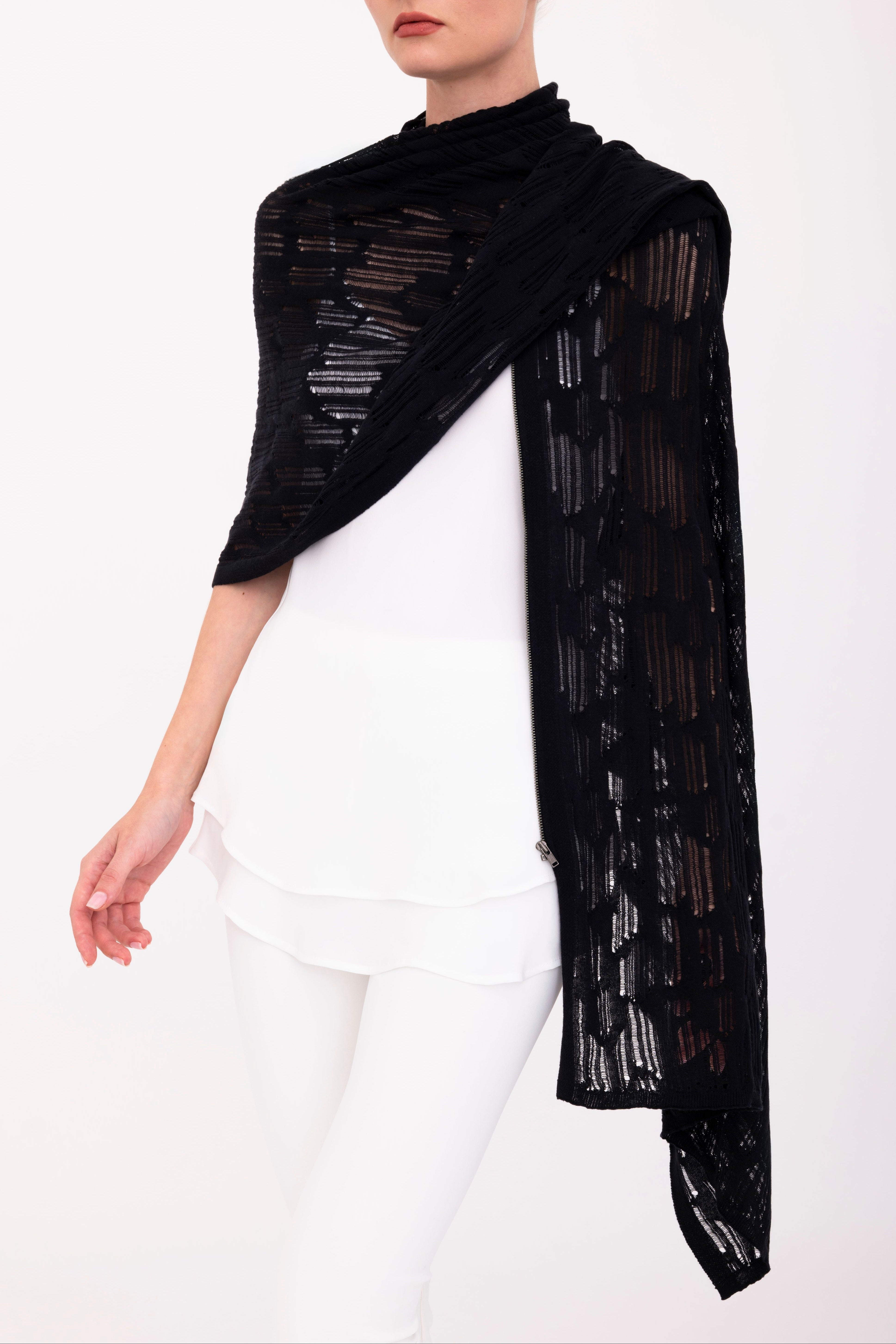 Woman wearing a black poncho top on a white background