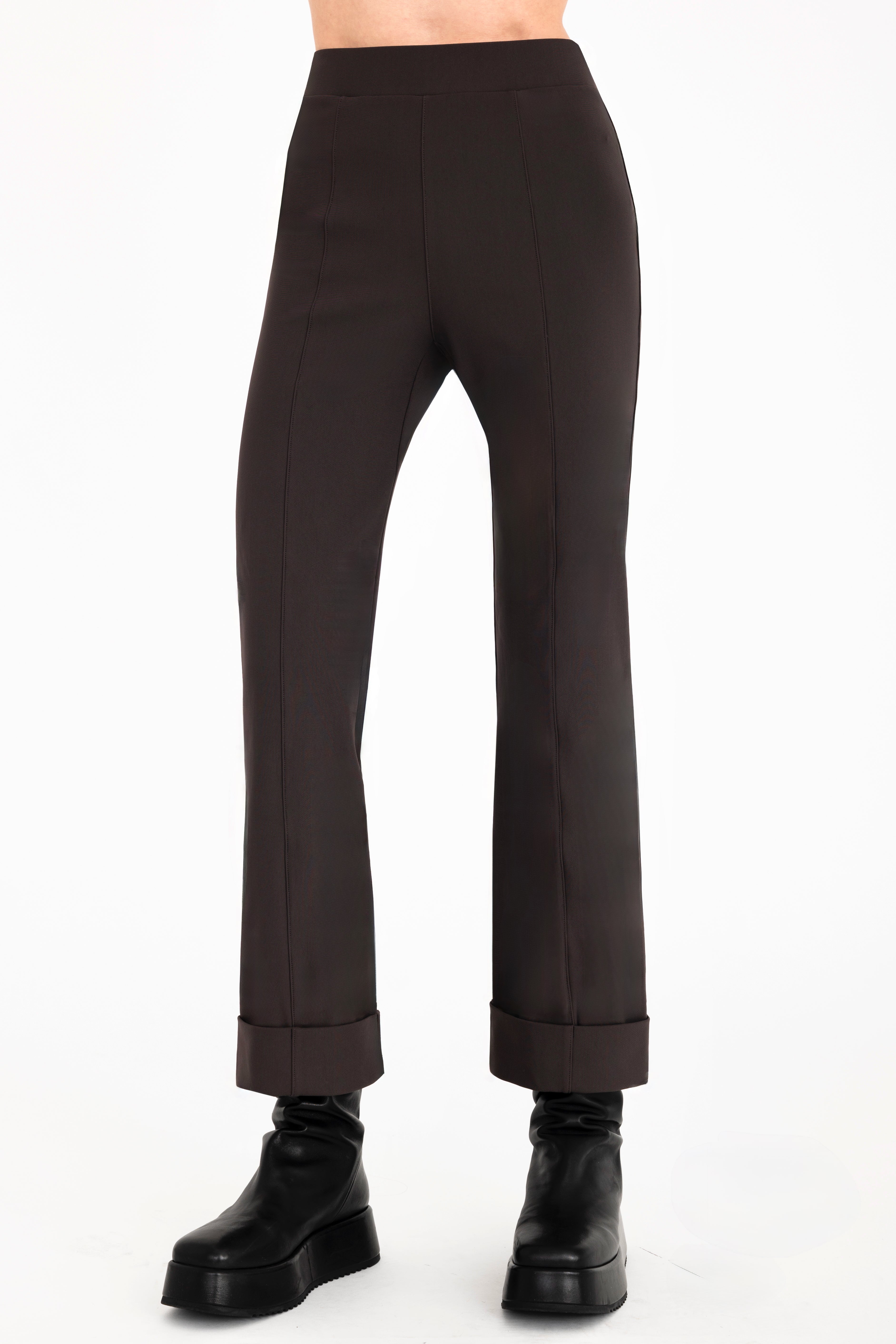 Dark brown pants worn by a person on a white background