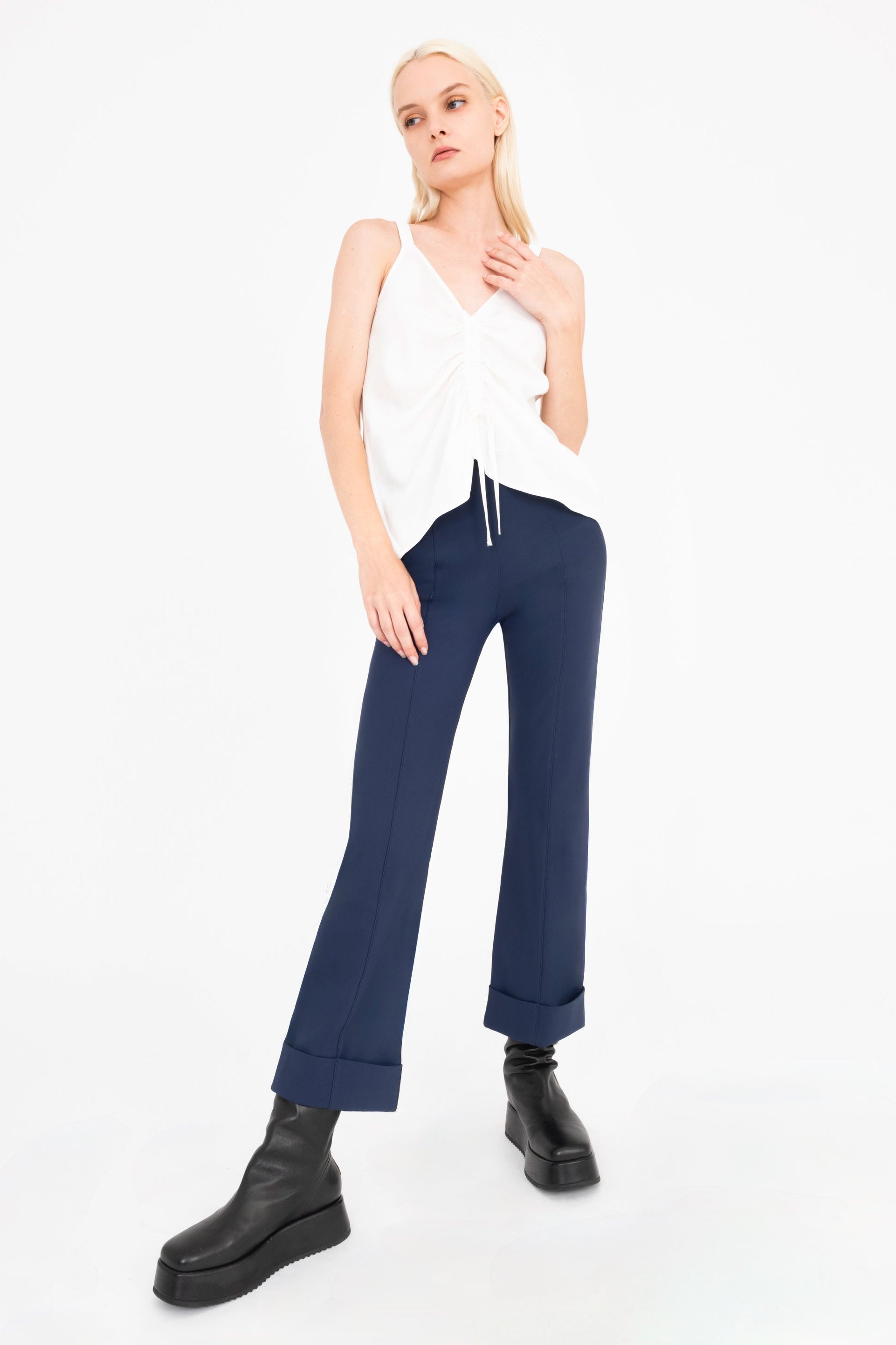 Woman wearing a white top and blue pants on a white background