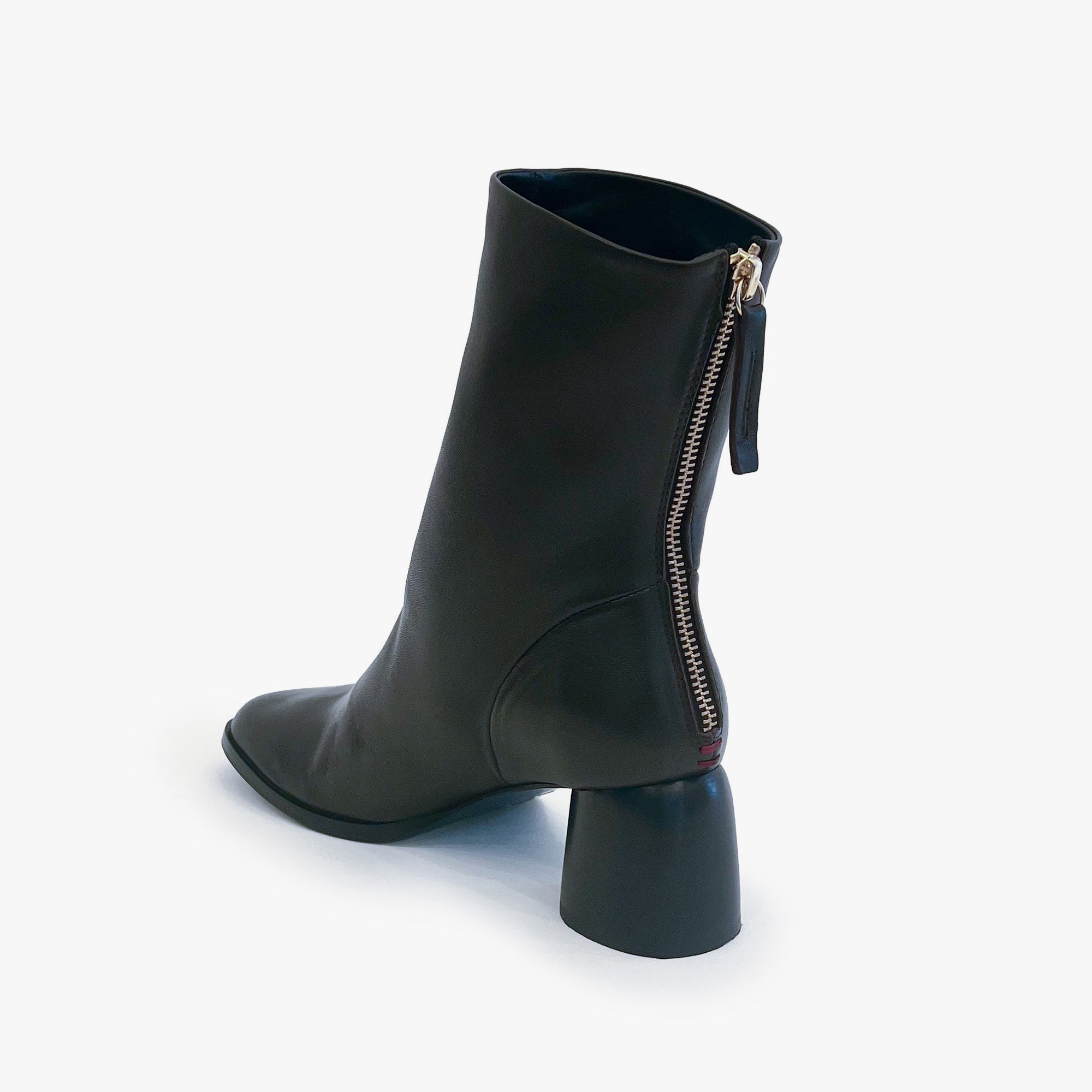 A dark brown leather ankle boot with a block heel and a side zipper, shown from a three-quarters angle on a light gray background.