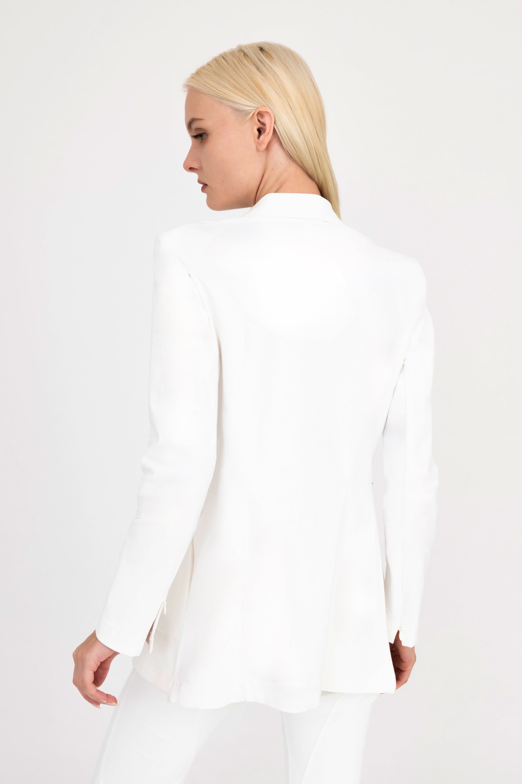 Woman wearing white blazer on a white background