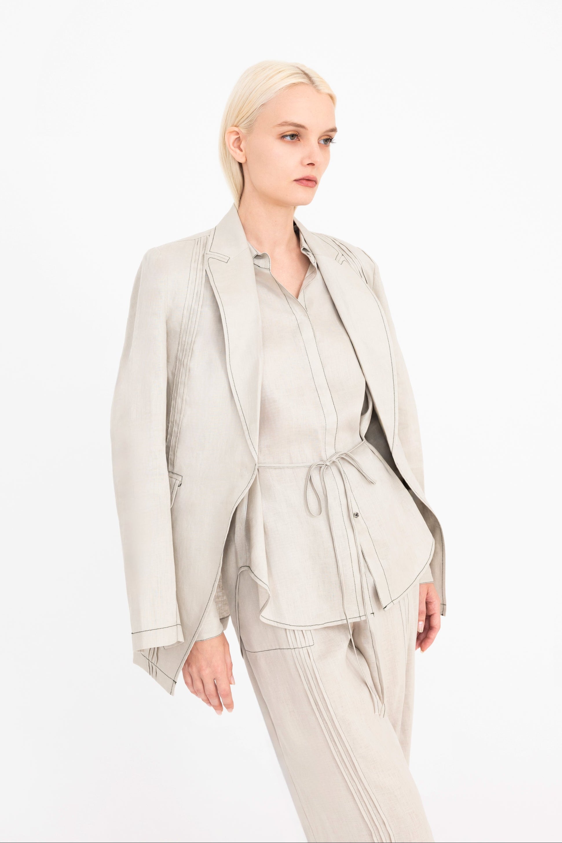 Woman wearing a light beige suit on a white background