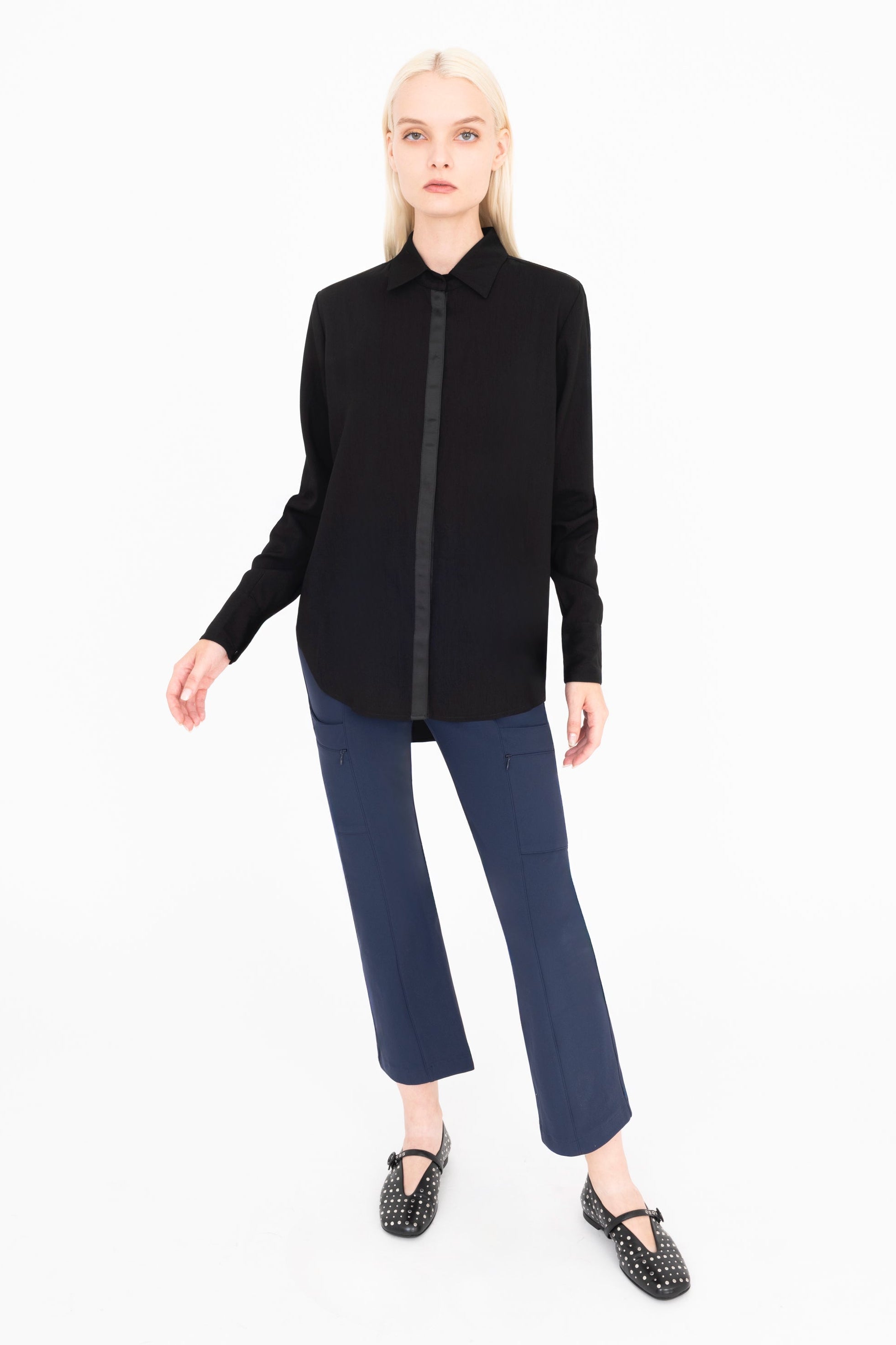 Woman wearing a black shirt and blue pants on a white background