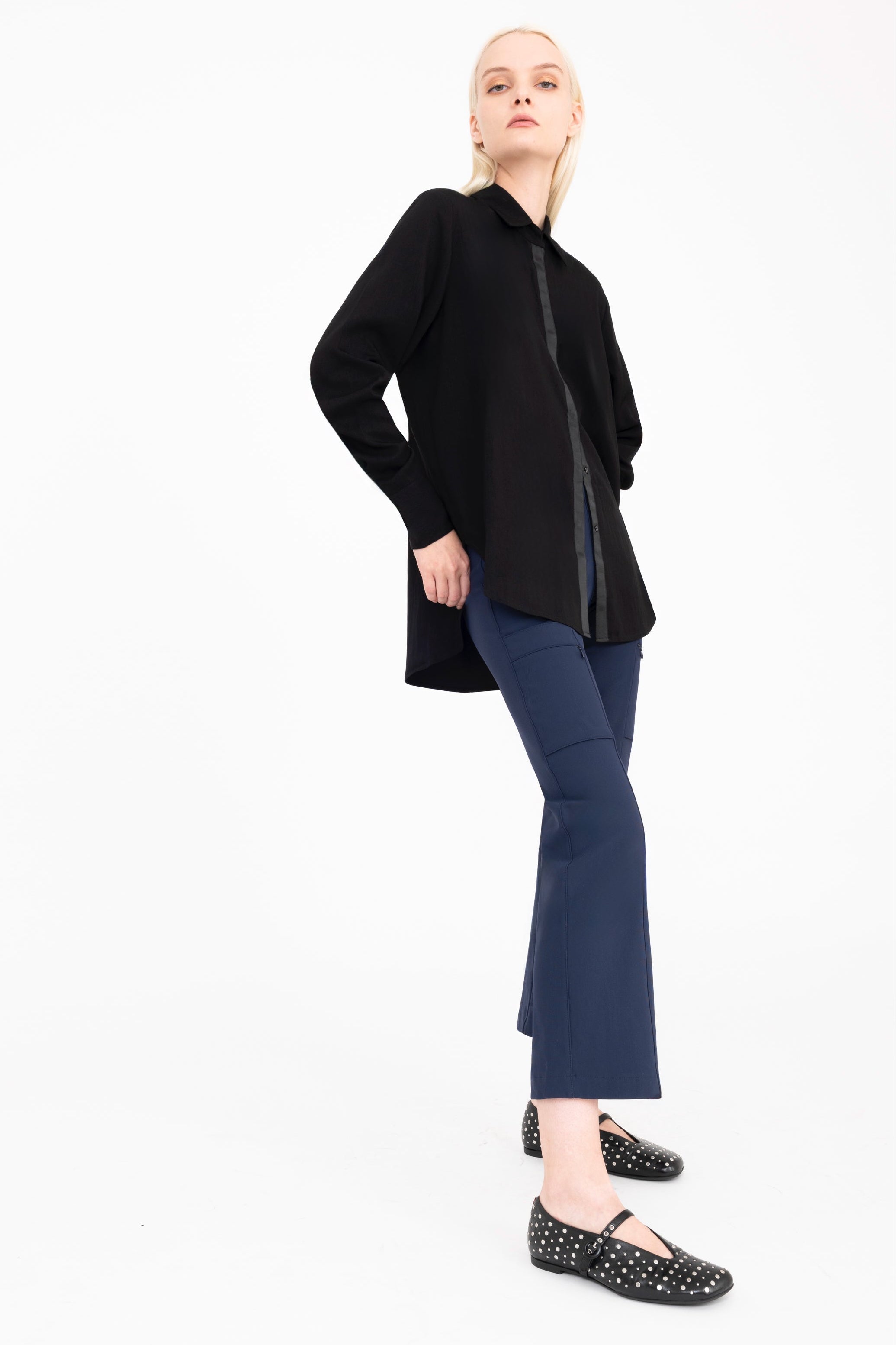 Woman wearing a black shirt and blue pants on a white background