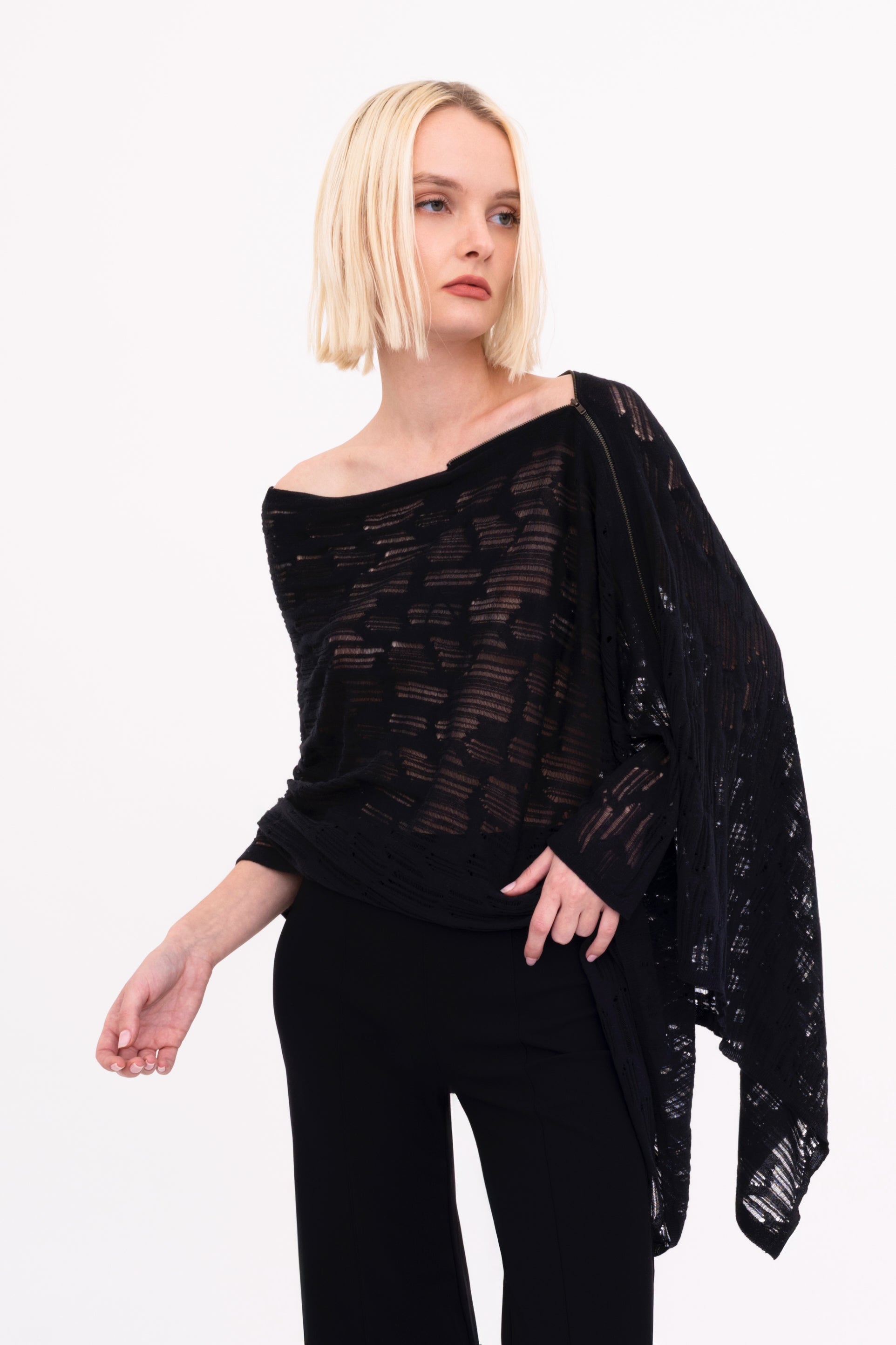Woman wearing a black poncho top on a white background