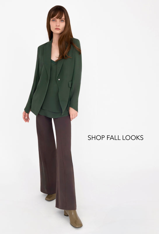 Woman wearing a green blazer and brown pants on a white background with 'Shop Fall Looks' text.