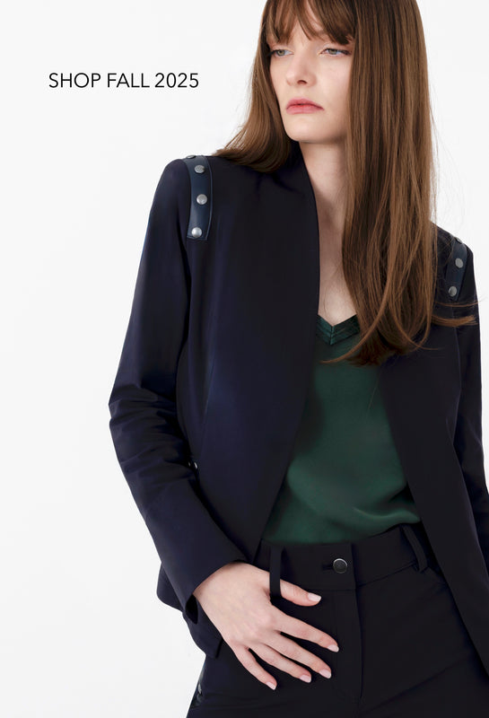 Woman wearing a dark navy blazer with cut-out shoulders on a white background, with text 'SHOP FALL 2025' above.