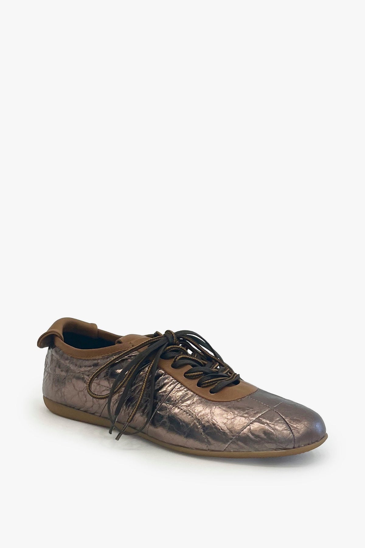A single metallic bronze sneaker with brown laces, shown from a three-quarters angle on a light gray background.