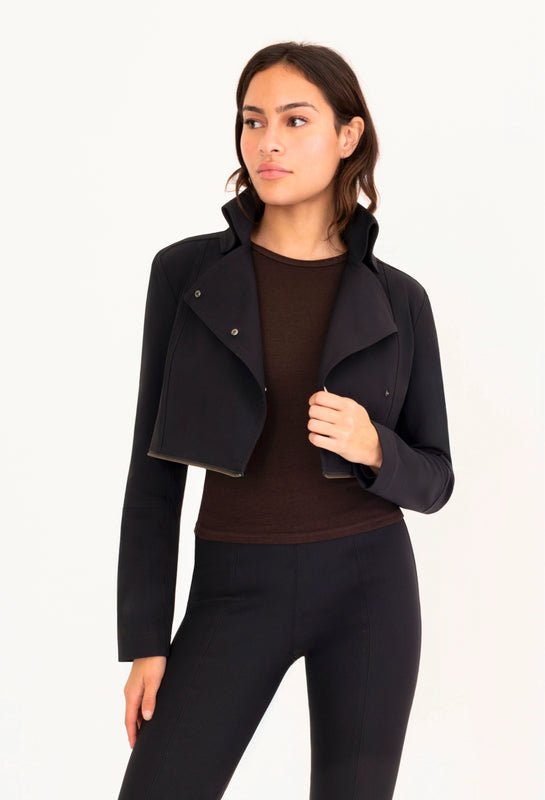 Woman wearing a black jacket and pants on a white background