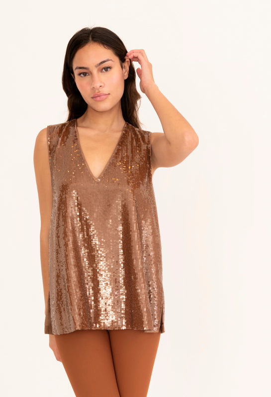 Woman wearing a bronze sequin sleeveless top on a white background