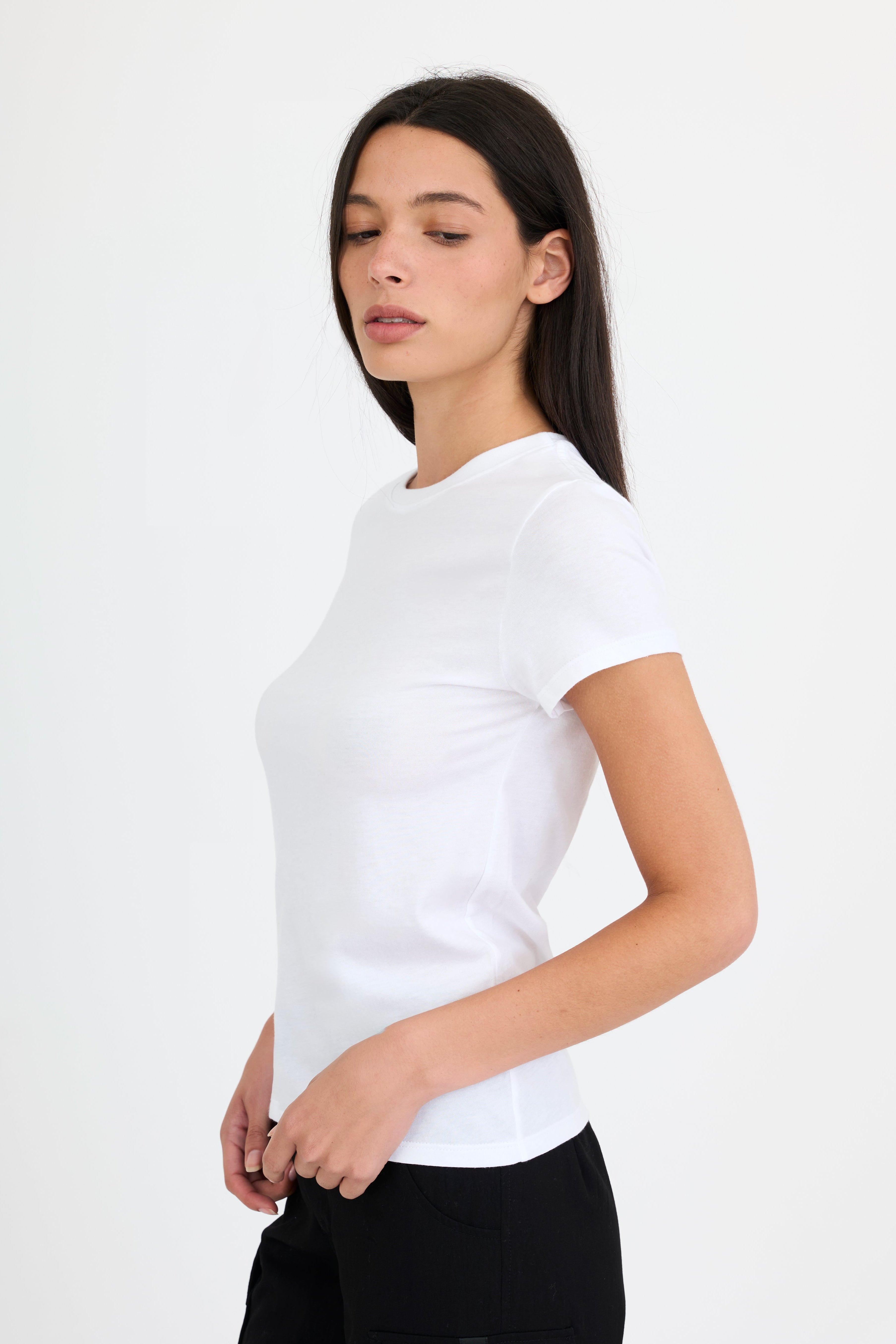 Woman wearing a white t-shirt and black pants on a white background
