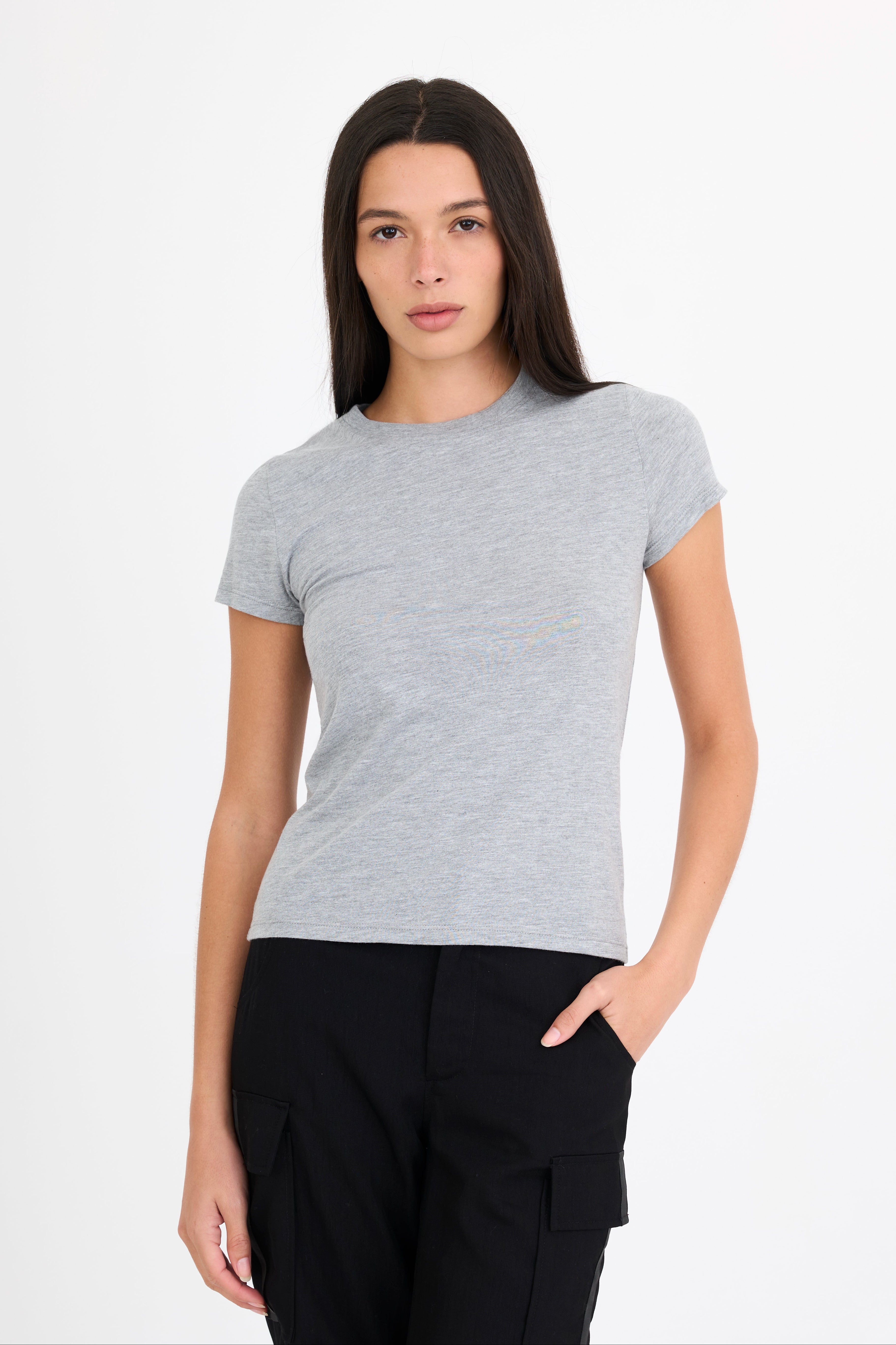 Woman wearing a gray t-shirt and black pants on a white background