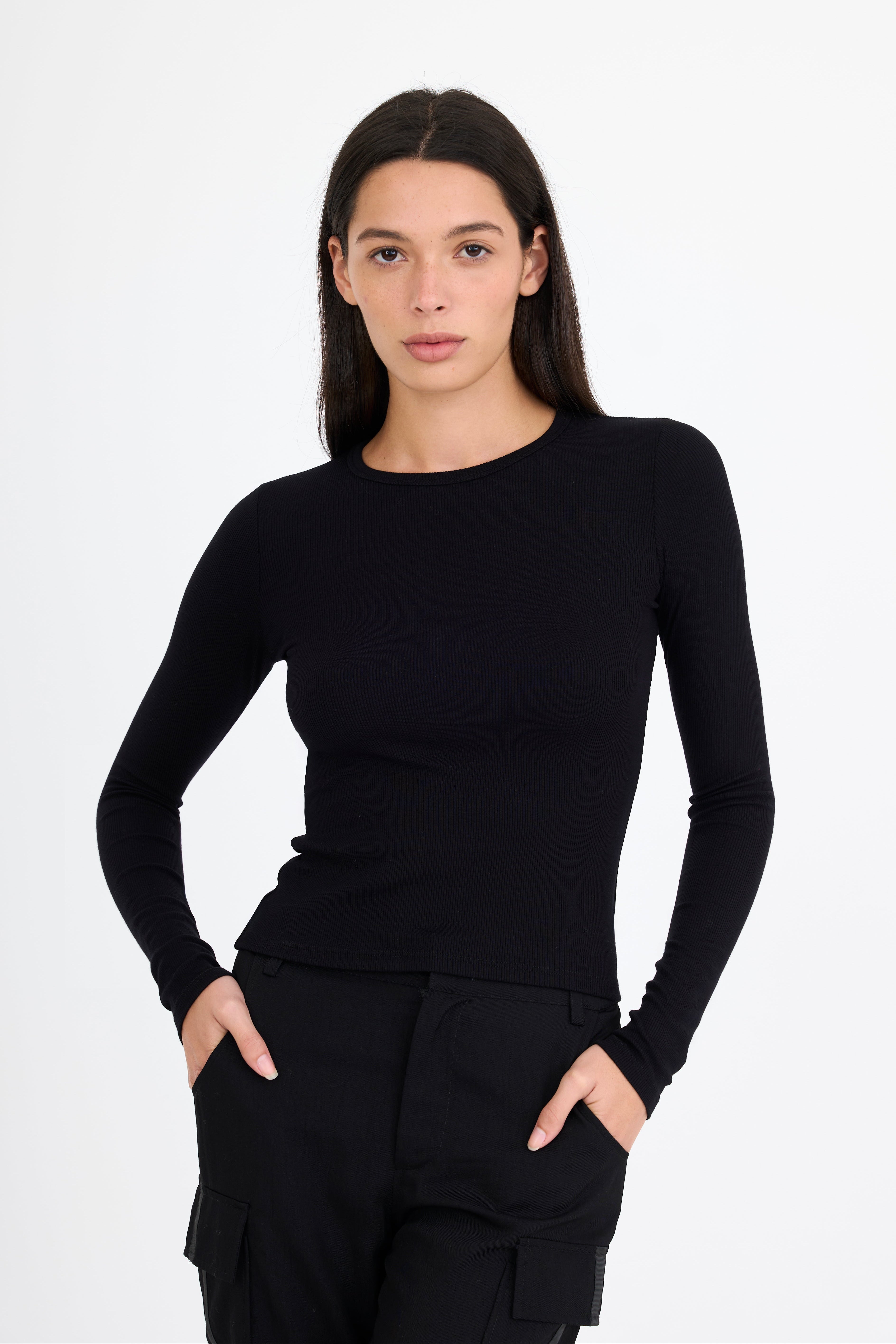 Woman wearing a black long-sleeve t-shirt and black pants on a white background