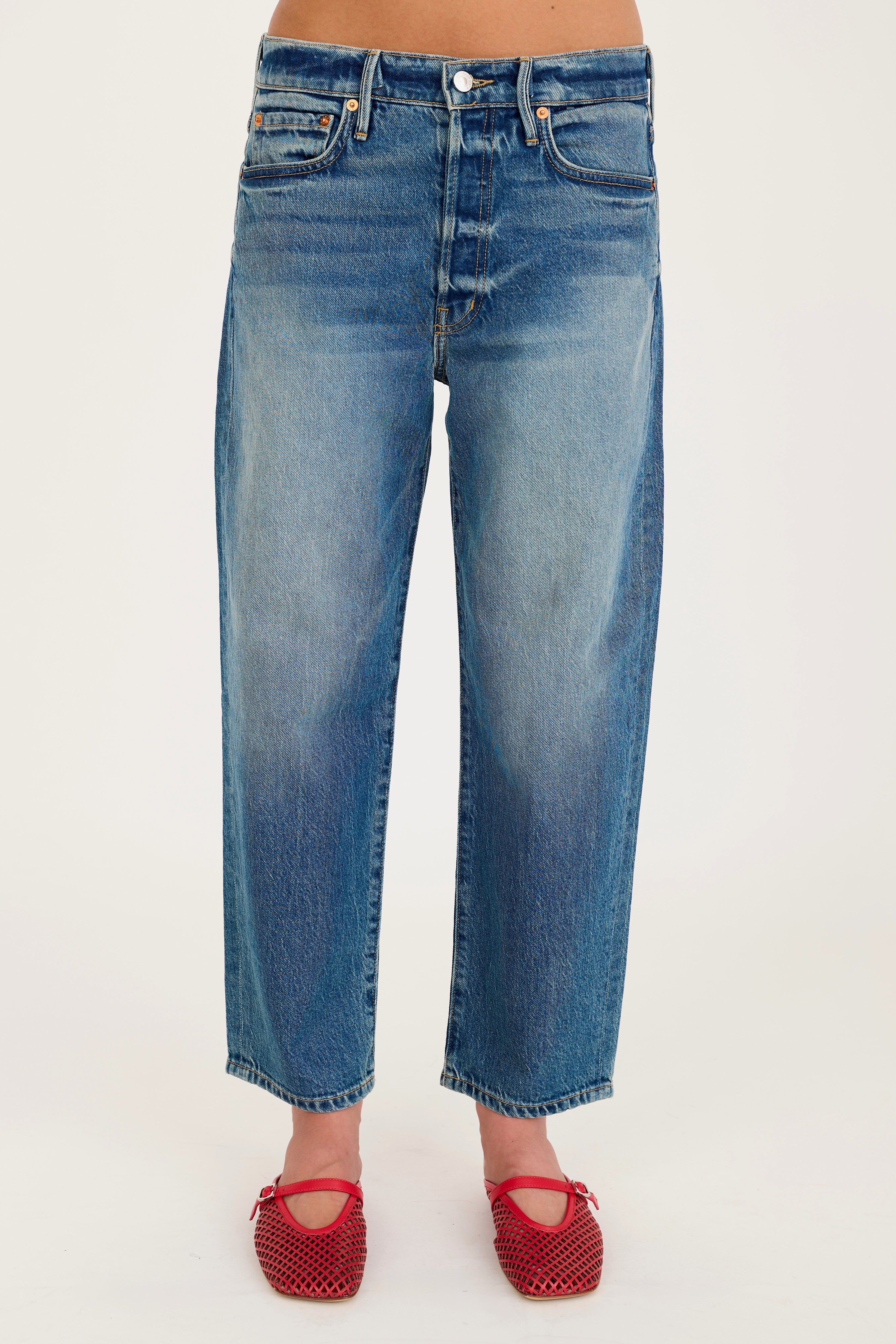 Blue jeans worn by a person on a white background