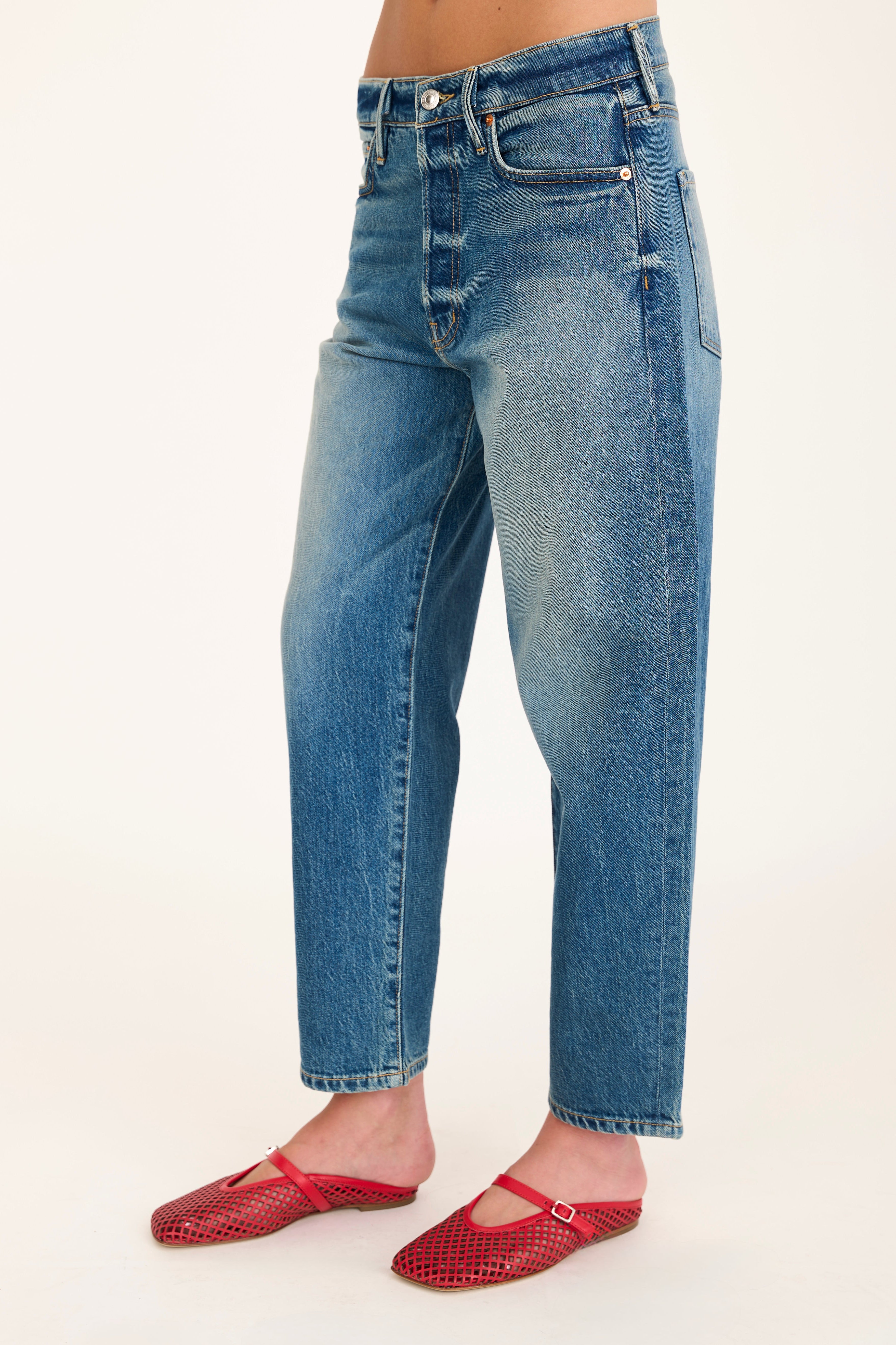 Blue jeans worn by a person on a white background