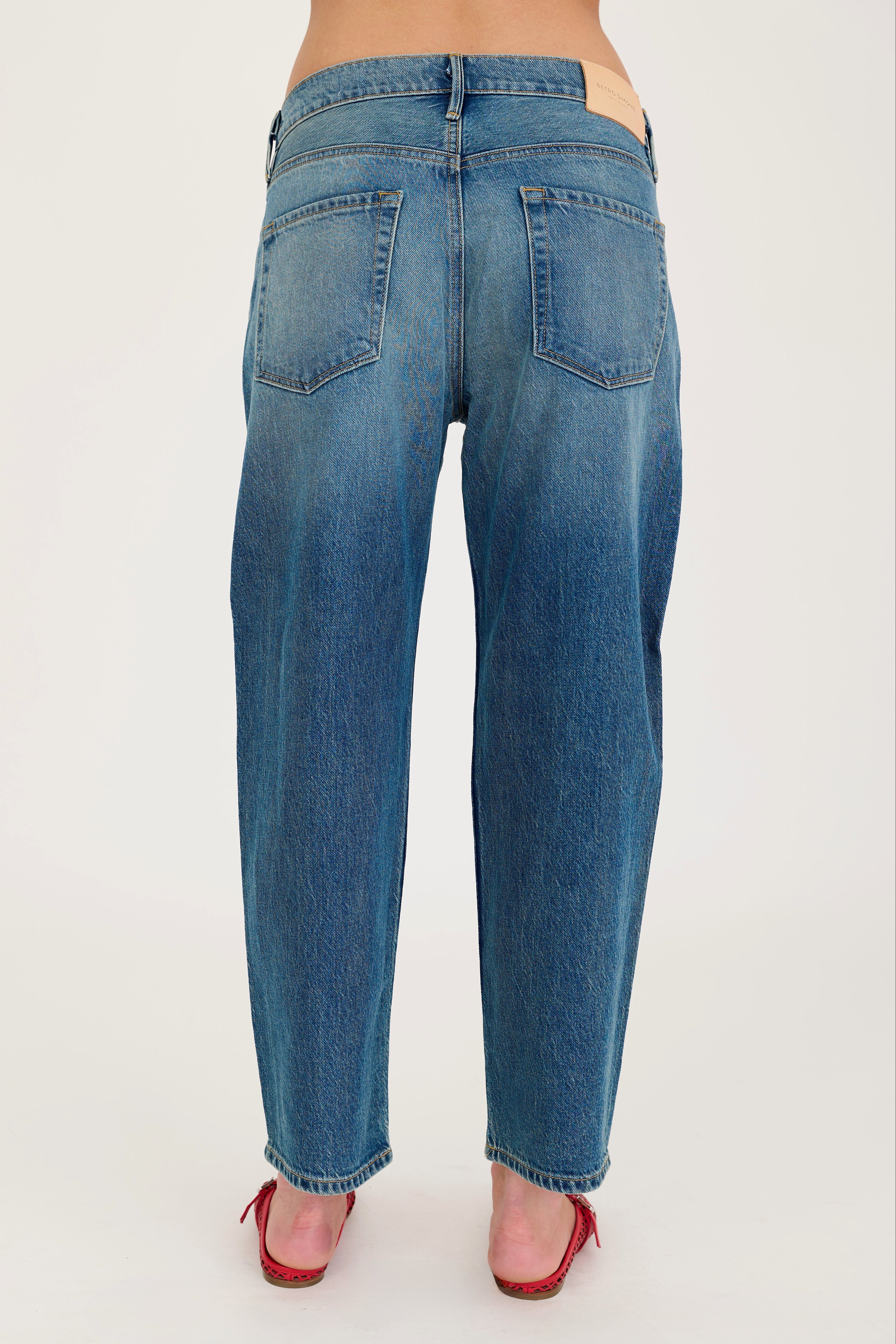 Blue jeans worn by a person on a white background