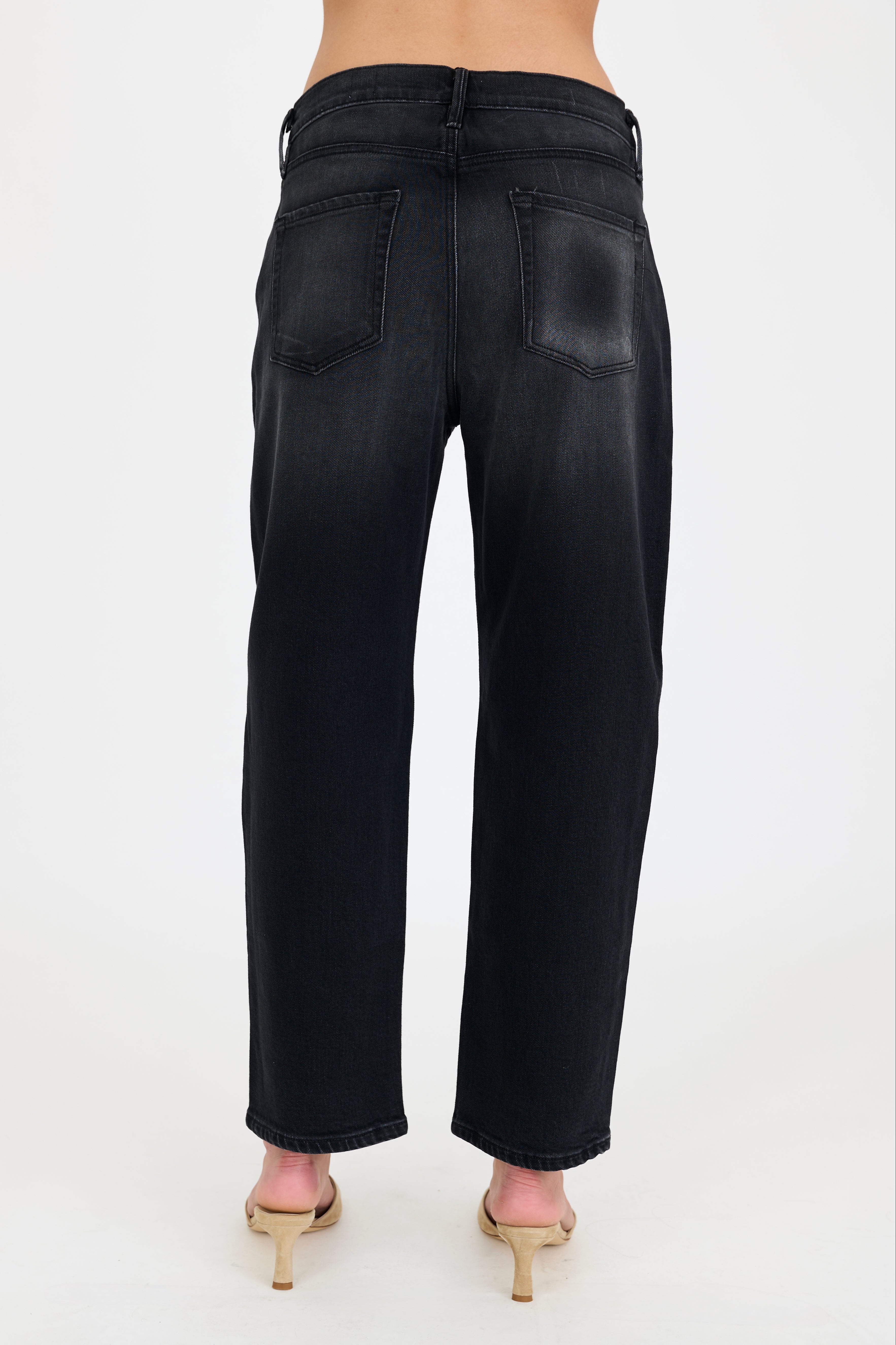 Black jeans worn by a person on a white background