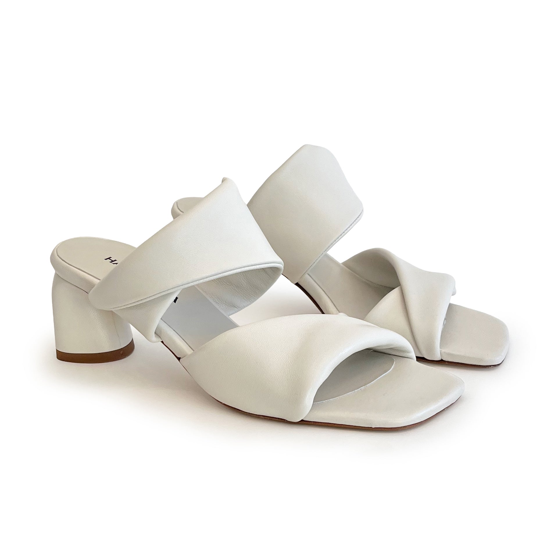 Ivory sculptured chunky heel sandals on a white background