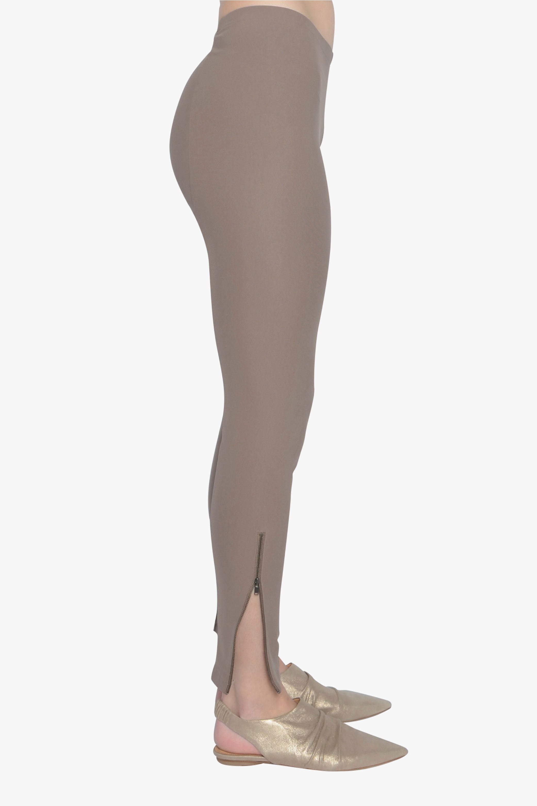 Beige leggings worn by a person on a white background