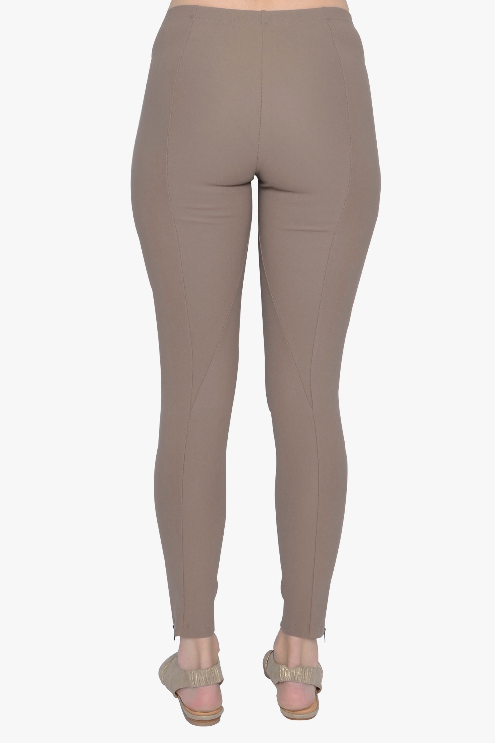 Beige leggings worn with sandals on a white background