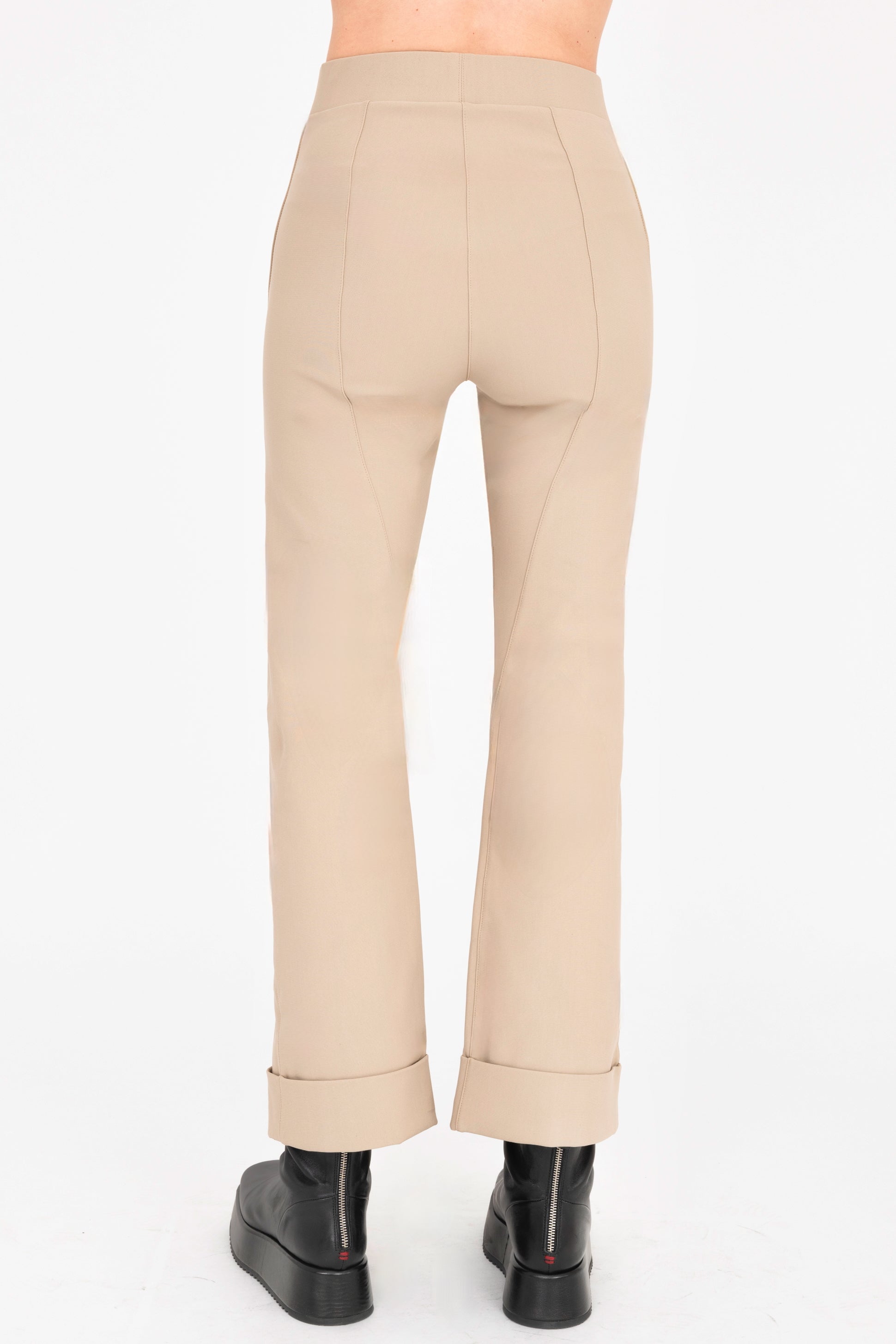 Beige pants worn by a person on a white background