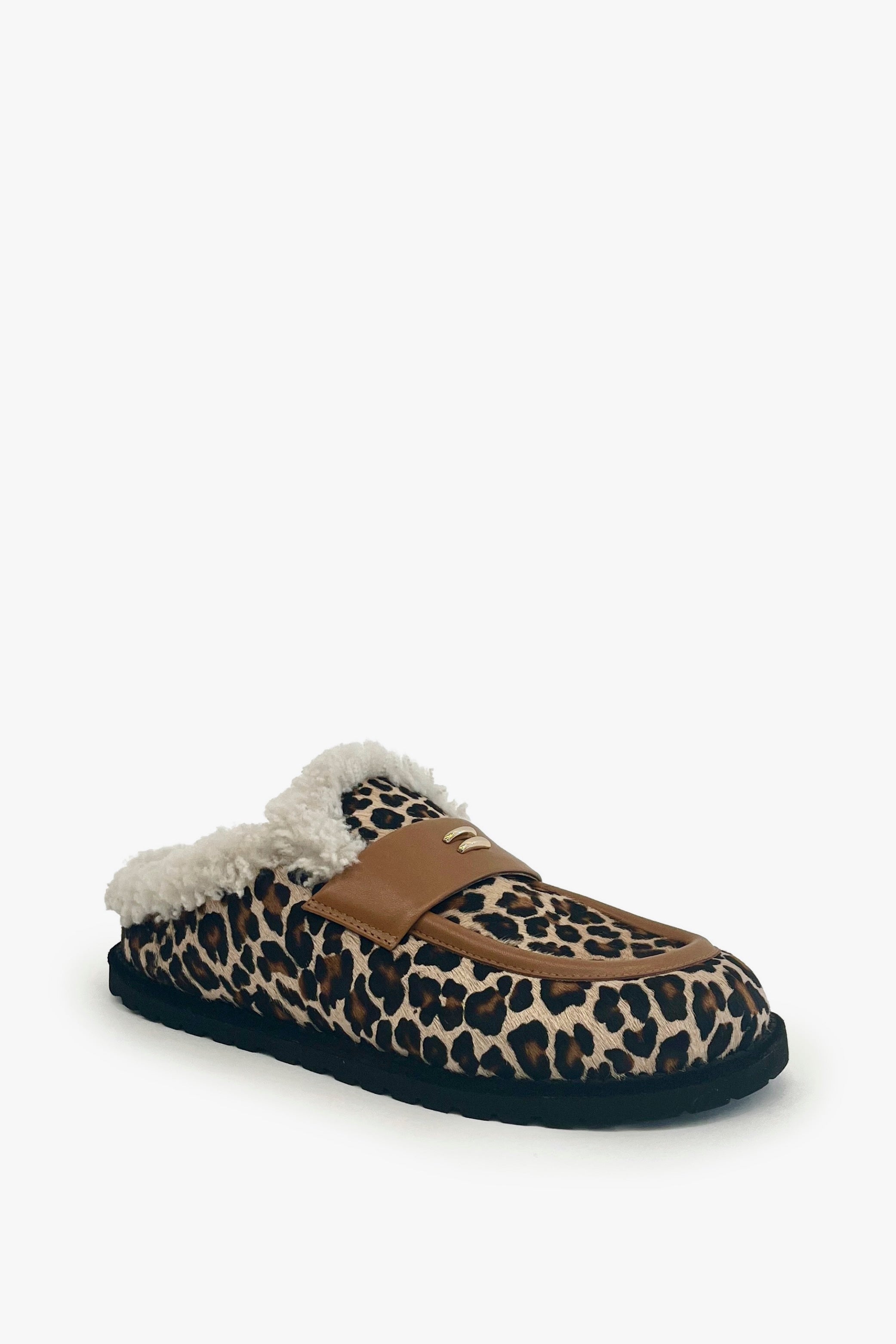 A single slip-on mule slipper featuring a brown, black, and beige leopard print pattern, a tan leather strap, and a fluffy white sherpa lining, shown against a plain white background.