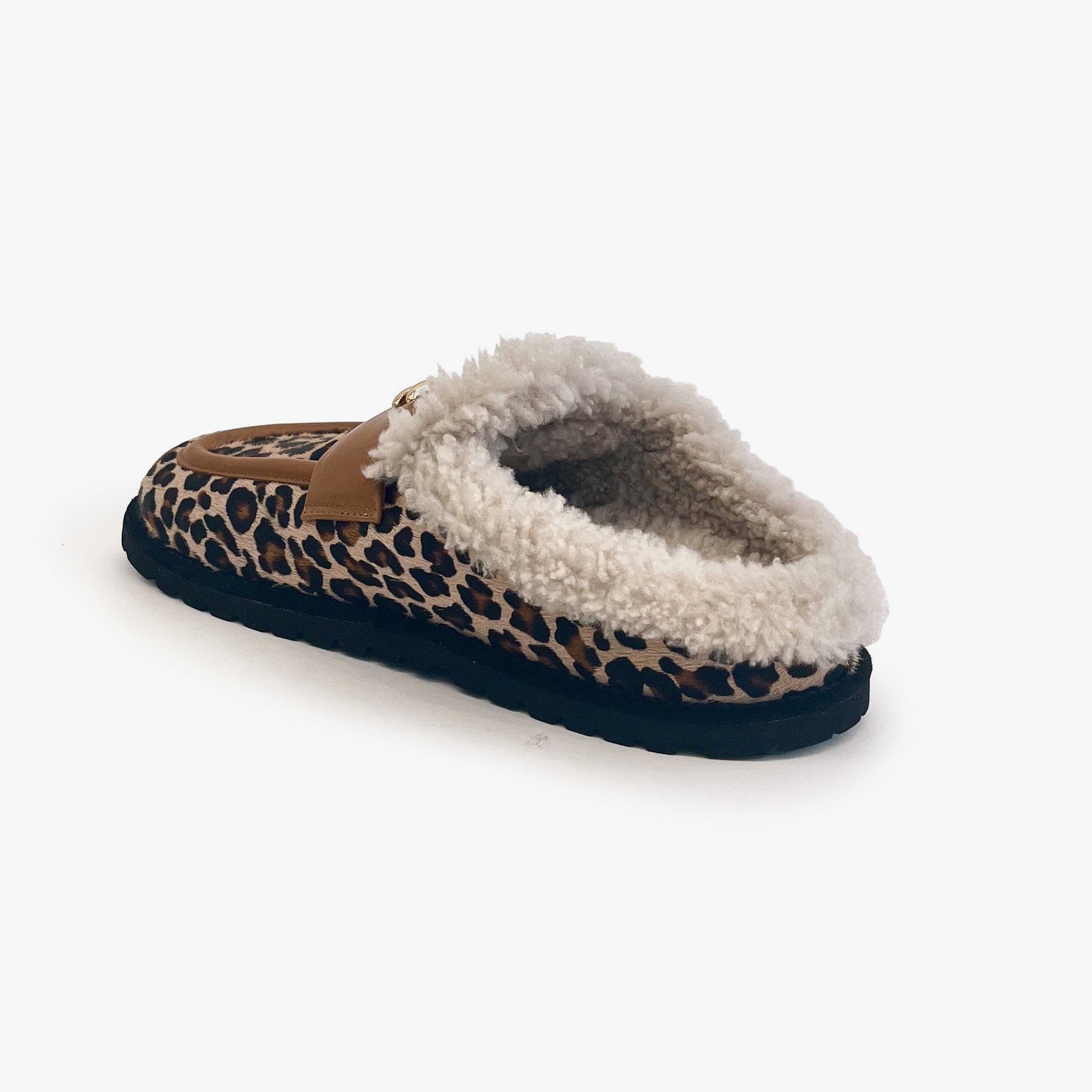 A single slip-on mule slipper featuring a brown, black, and beige leopard print pattern, a tan leather strap, and a fluffy white sherpa lining, shown against a plain white background.