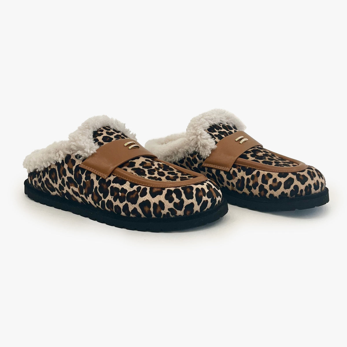 A pair of slip-on mule slippers featuring a brown and black leopard print pattern, tan straps, and fluffy white shearling lining, shown against a plain light gray background.