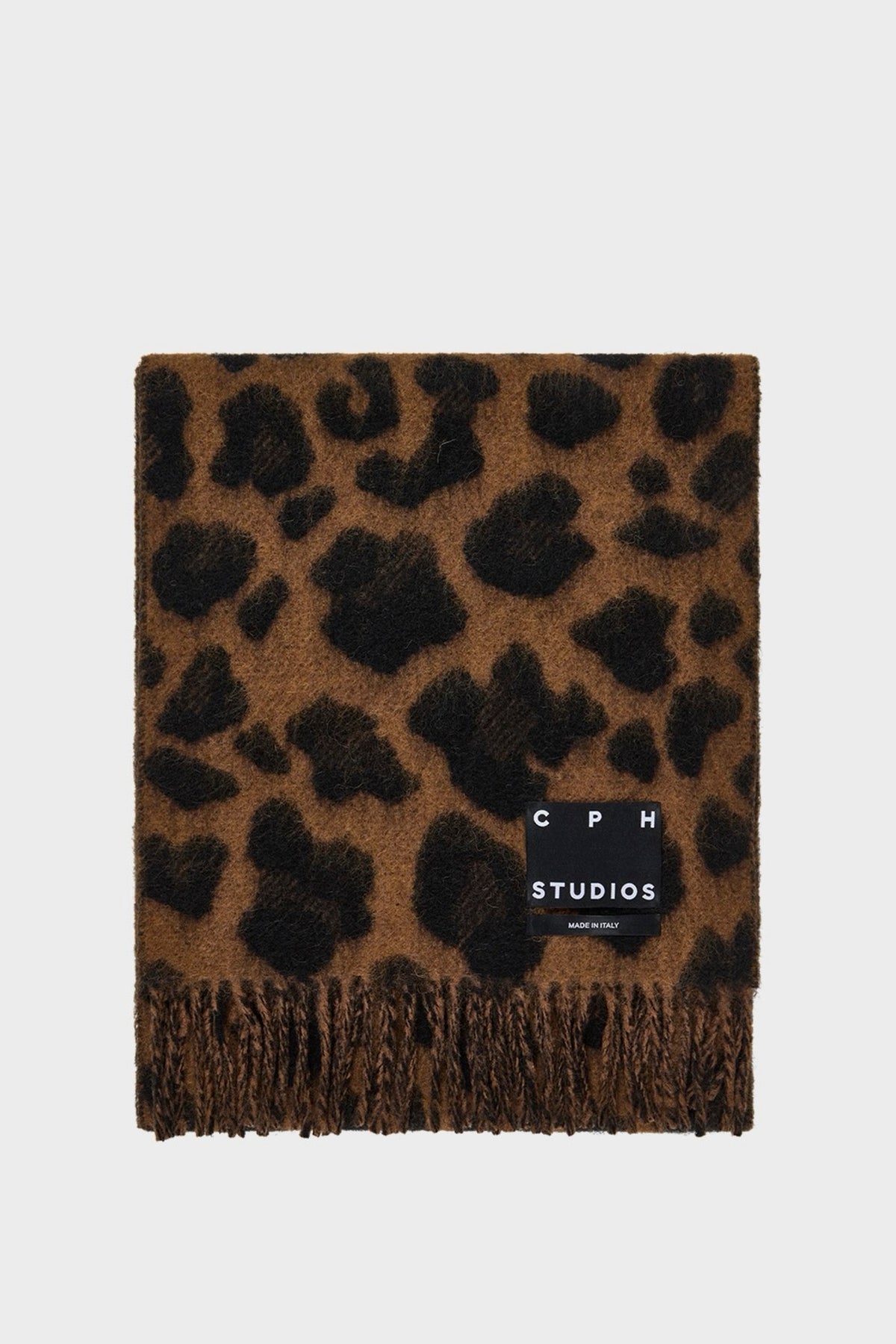 A brown and black leopard print shawl with fringed edges and a black brand label reading 'CPH STUDIOS' on a light gray background.