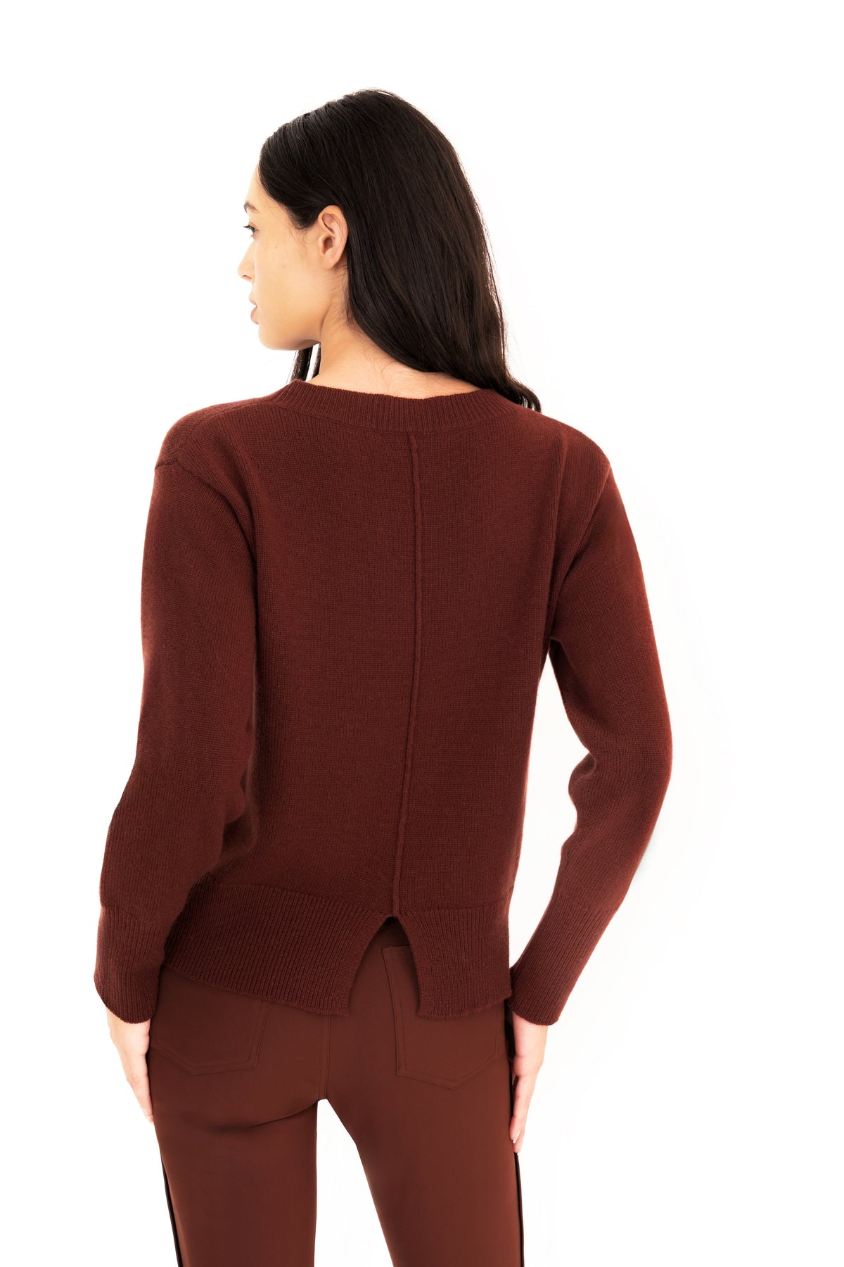 A woman shown from the back wearing a dark brown knit sweater and matching pants against a plain white background.