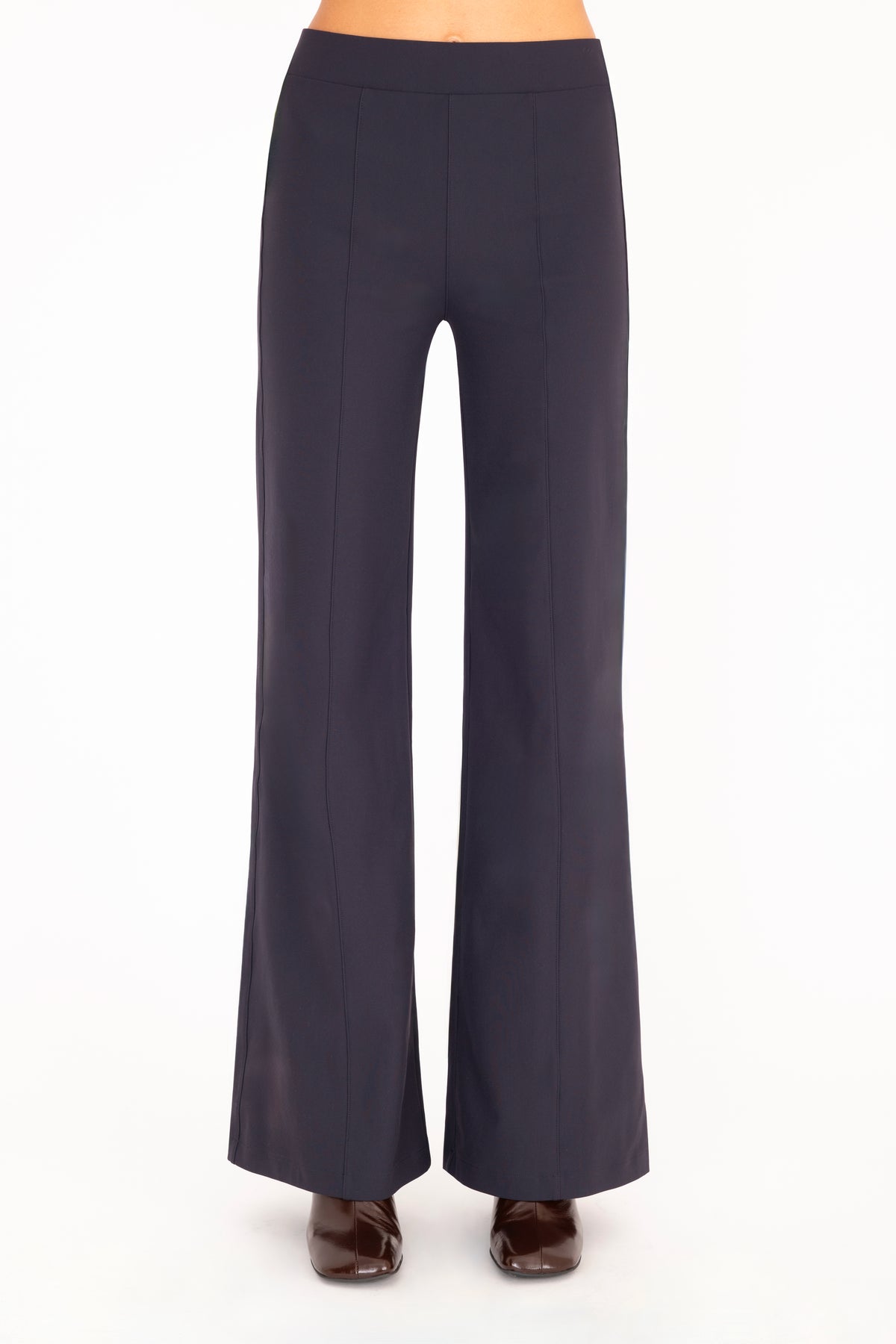 A model wearing high-waisted, wide-leg navy blue pants with dark brown boots, shown from the waist down against a plain white background.