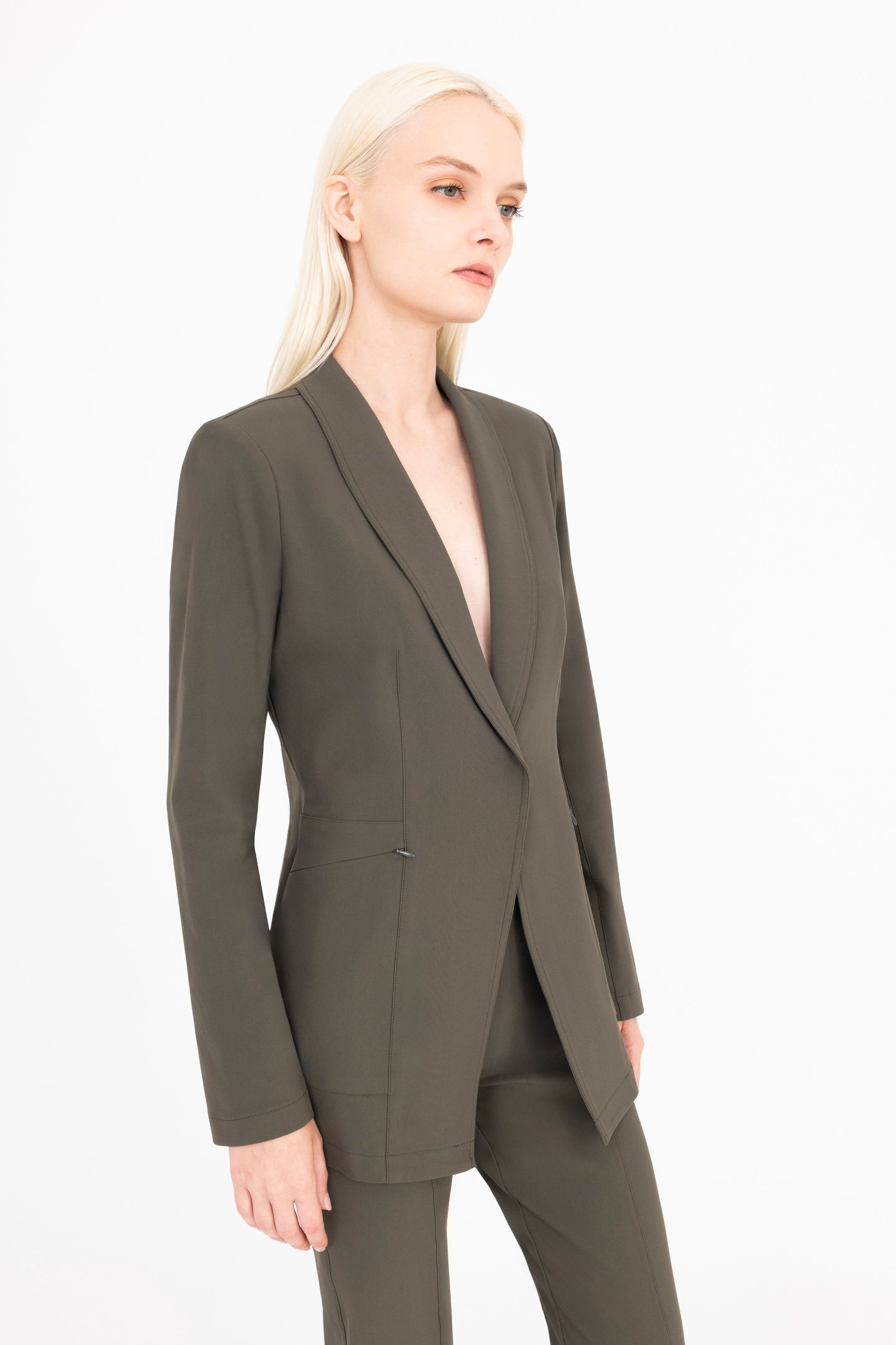 Woman wearing a olive suit on a white background