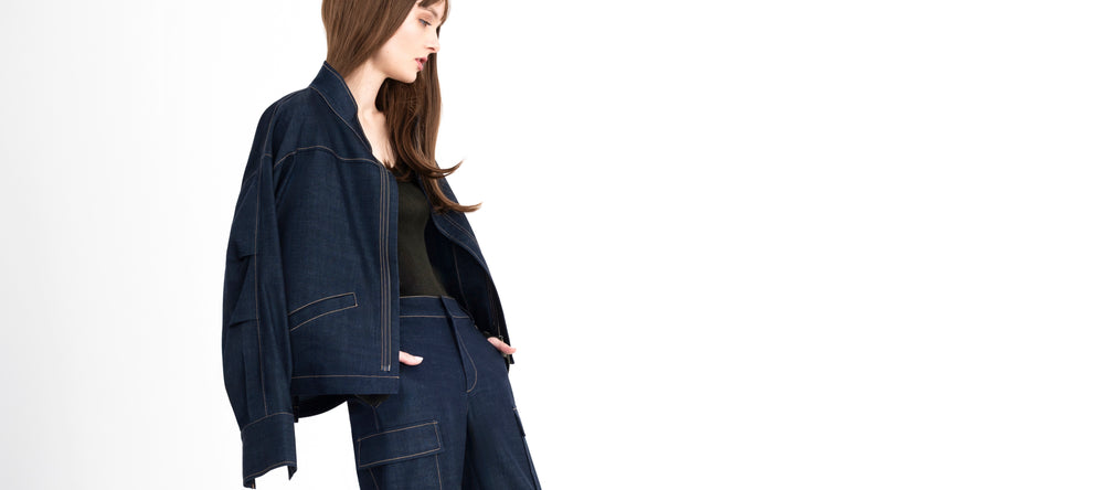 Woman wearing a dark blue jacket and pants on a white background