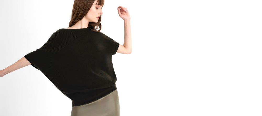 Woman wearing a green top and green skirt on a white background