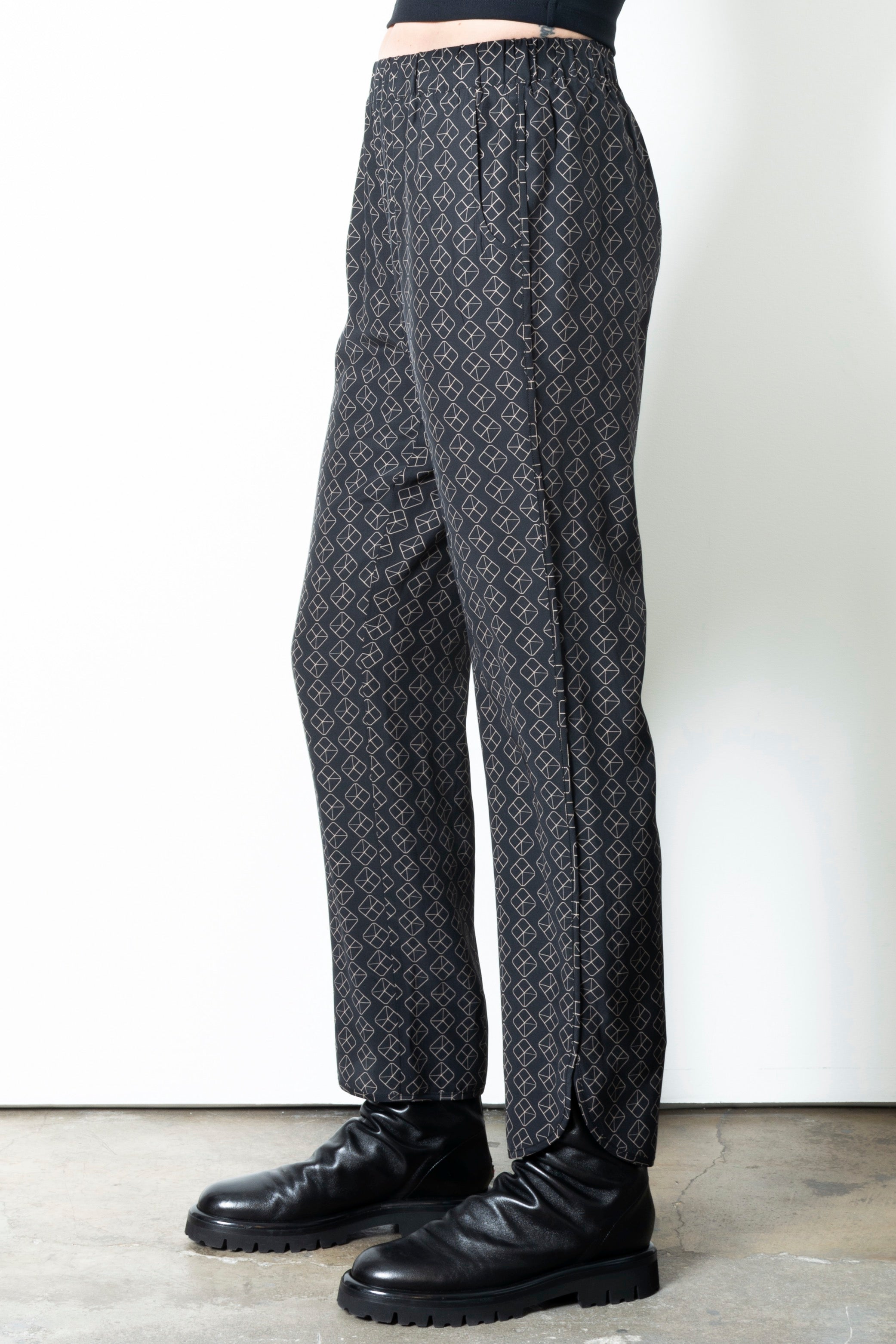 Person wearing patterned pants on a plain background