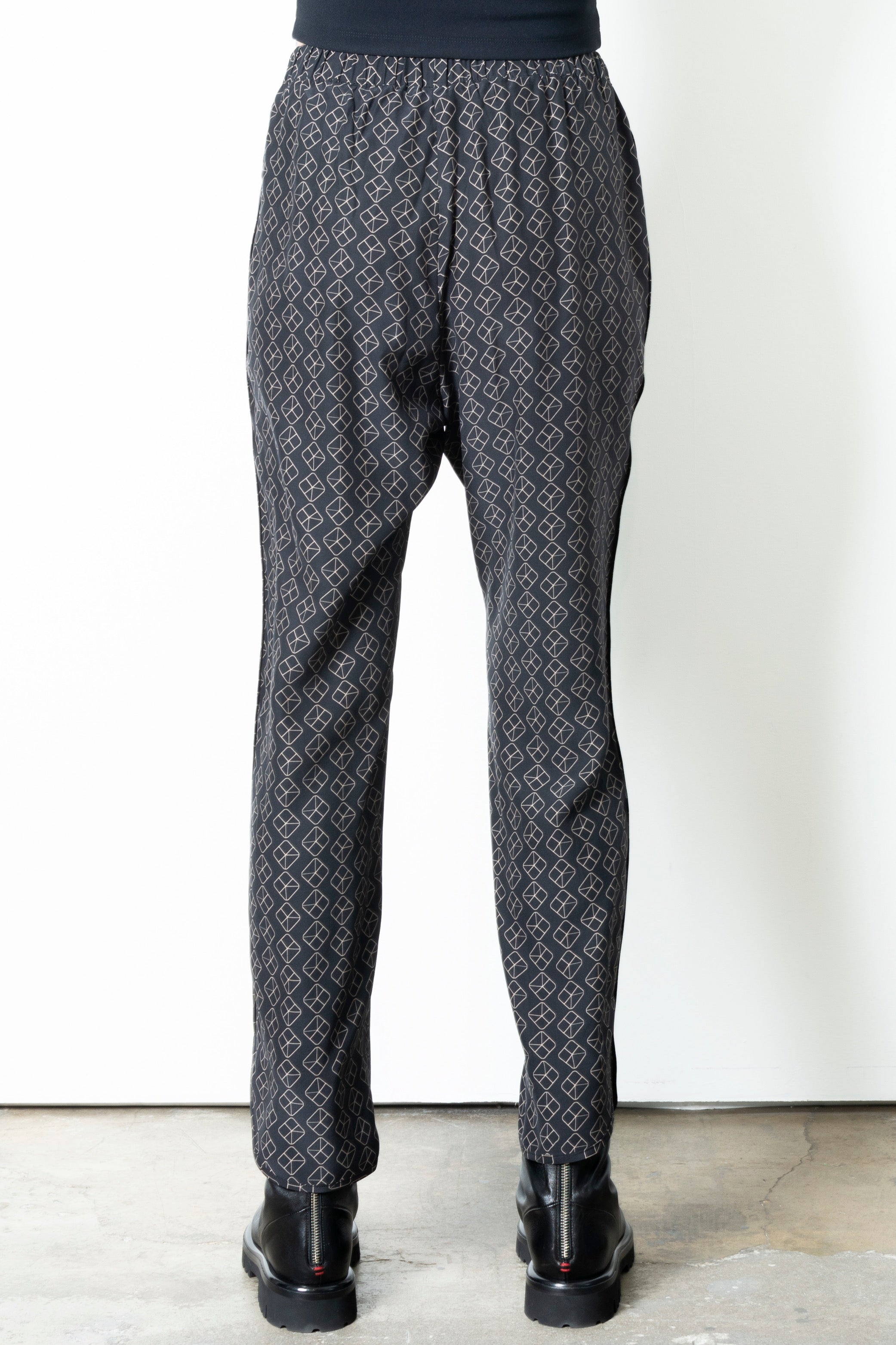 Person wearing patterned pants on a plain background