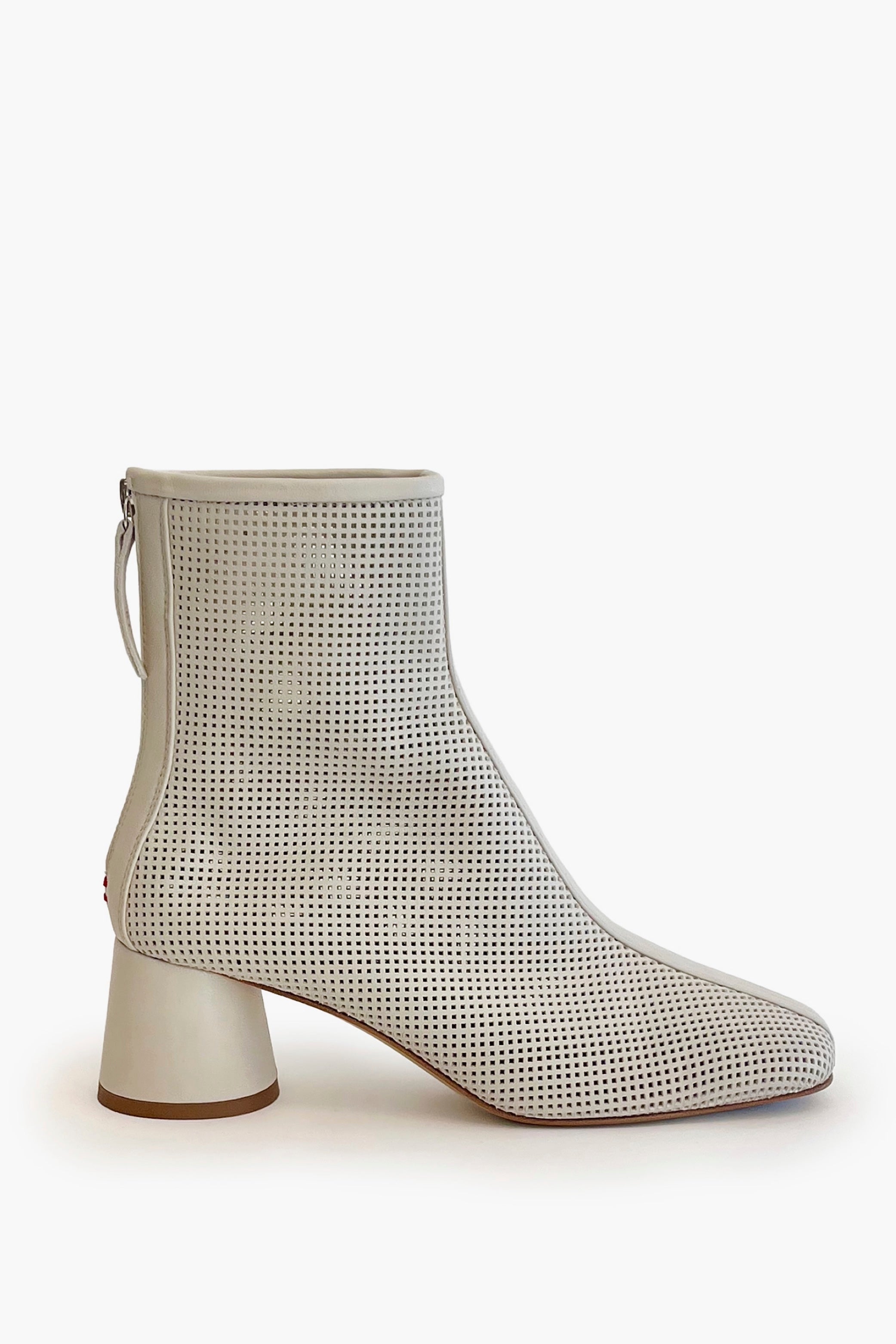 Beige round toe perforated ankle boot on a white background