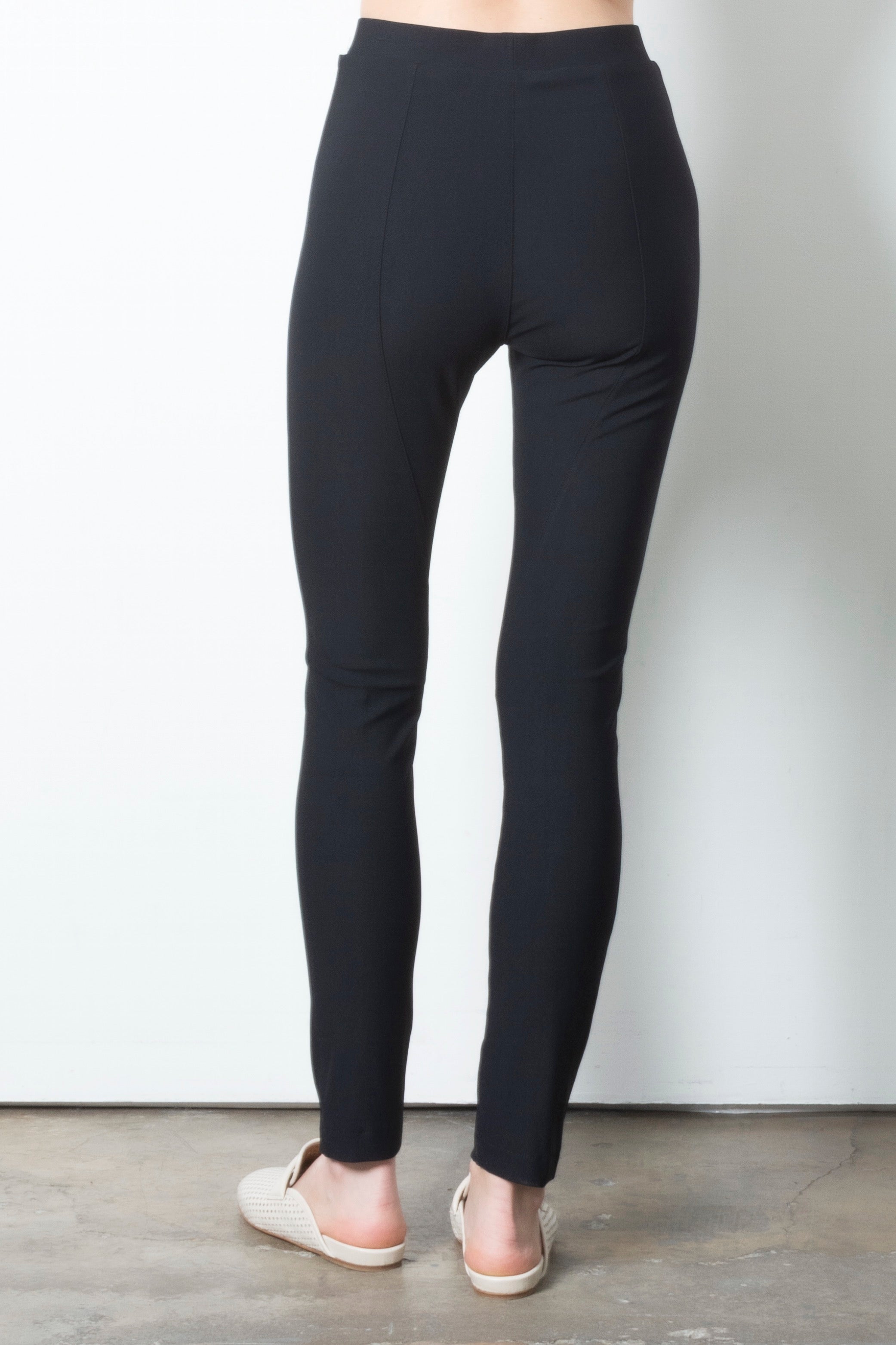 Black leggings worn by a person on a plain background