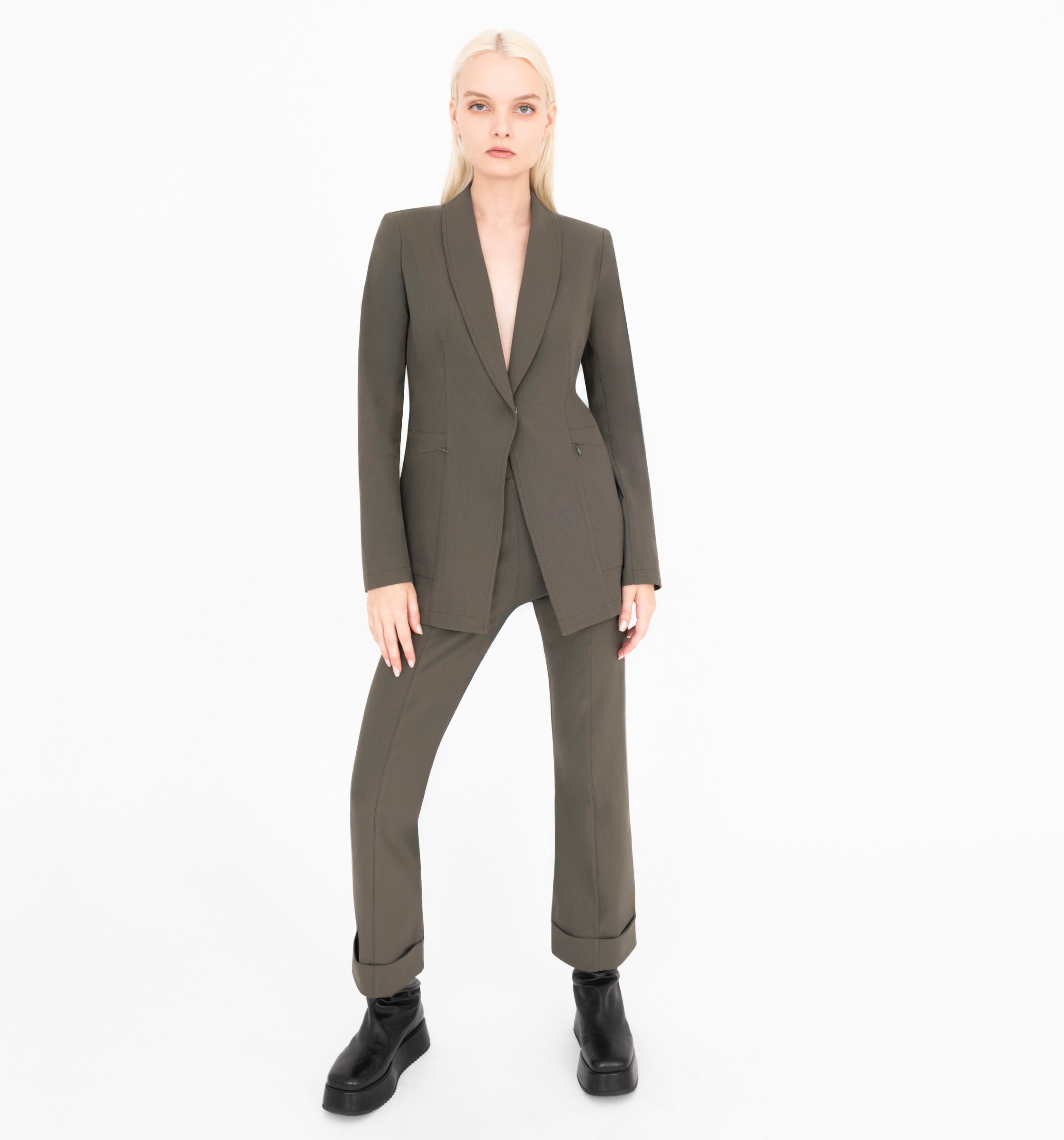 Woman wearing green  jacket and pants on a white background