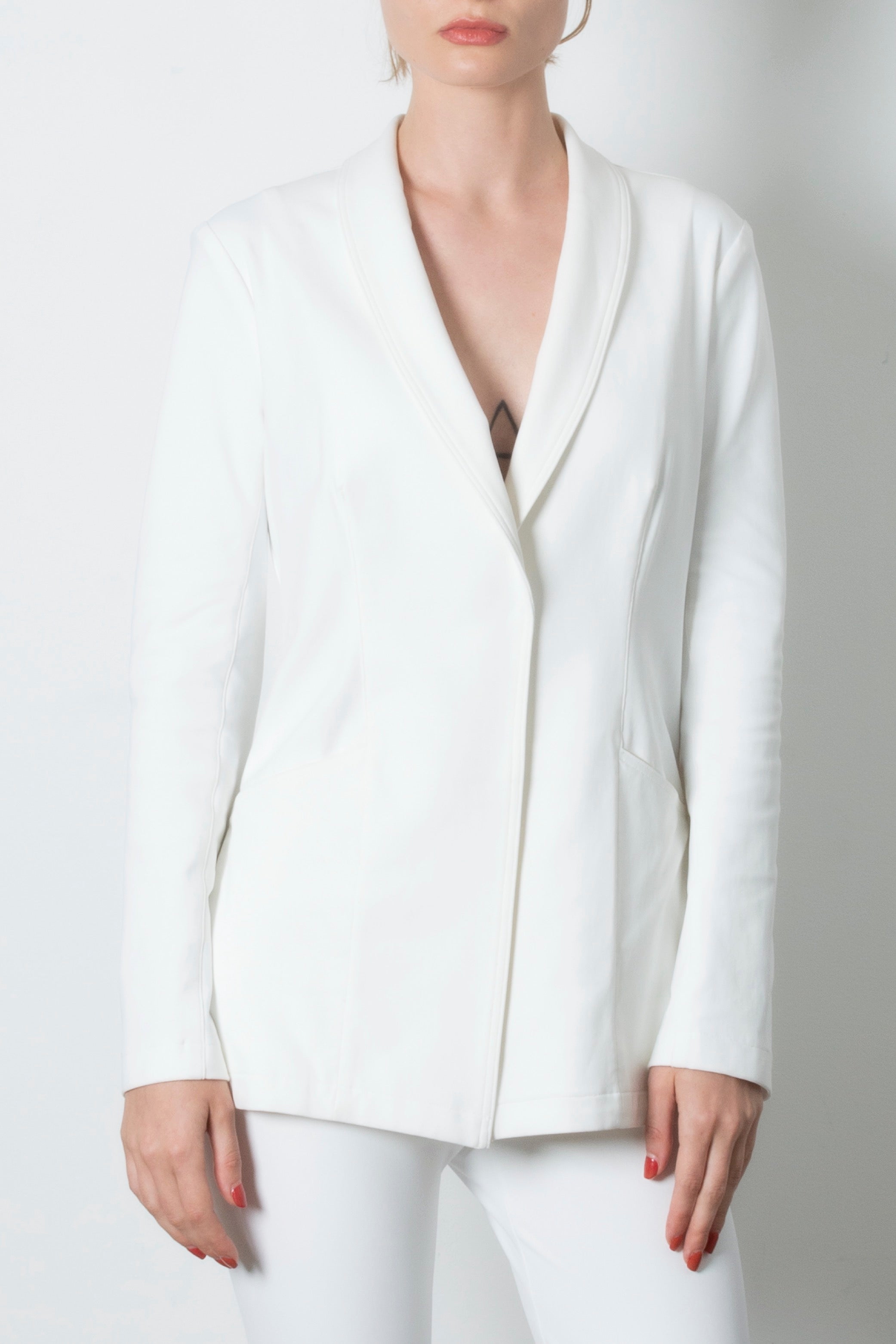 White blazer worn by a person on a plain background
