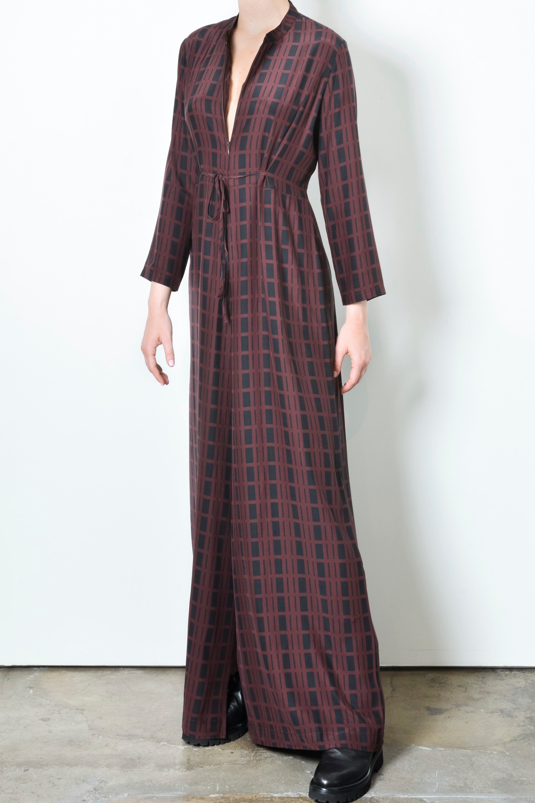 Long plaid jumpsuit worn by a person on a white background
