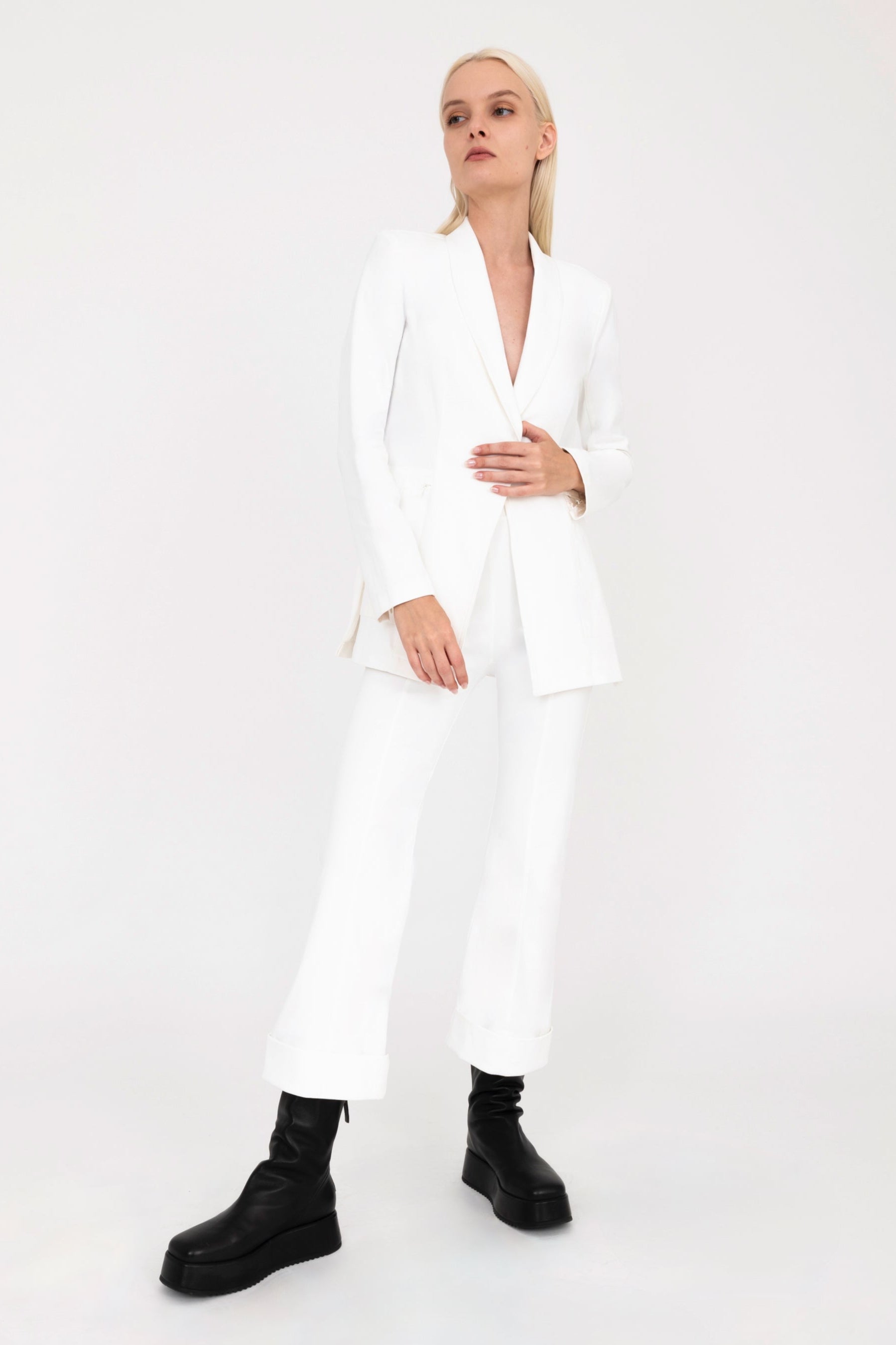 Woman wearing white jacket and pants on a white background