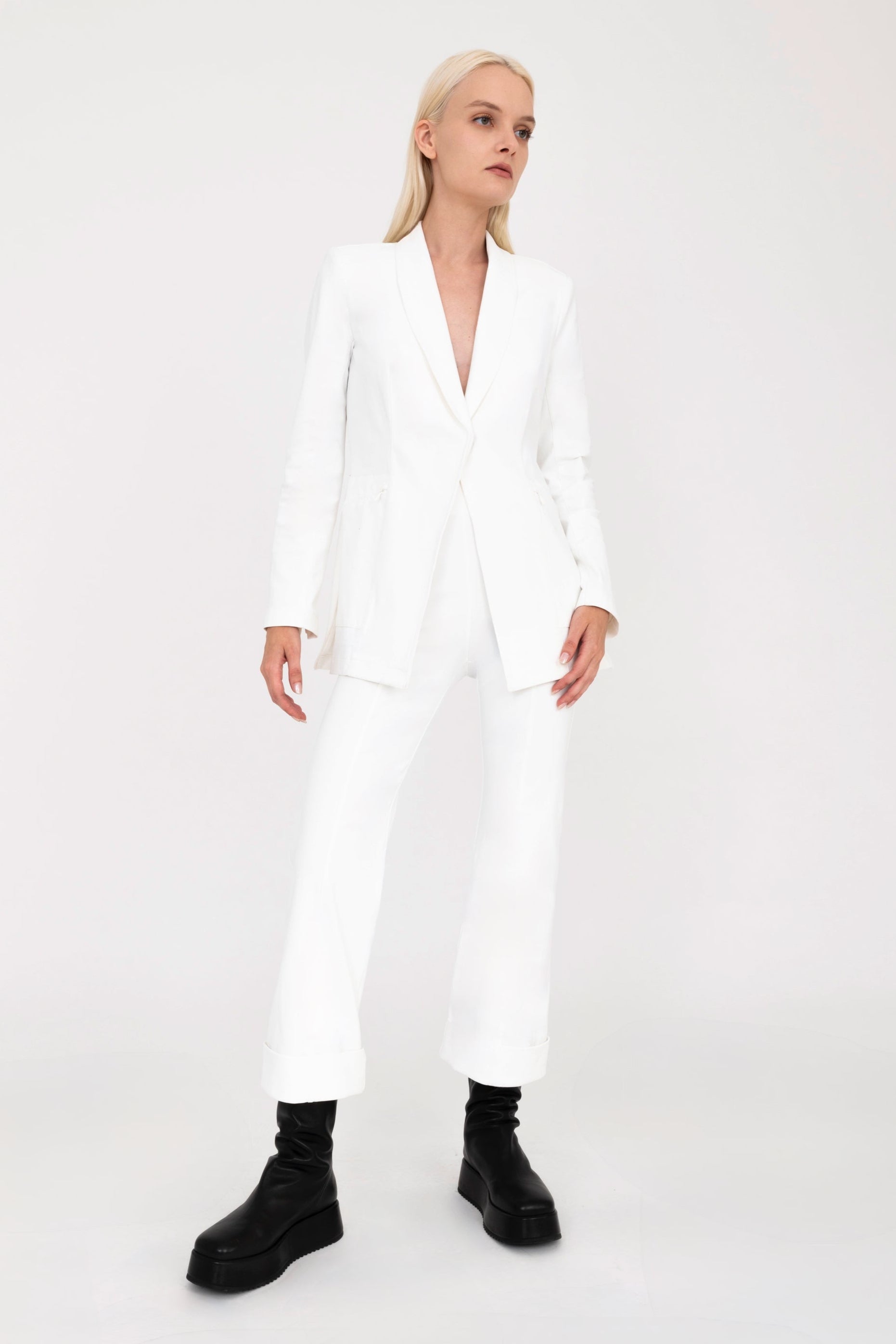 Woman wearing white jacket and pants on a white background
